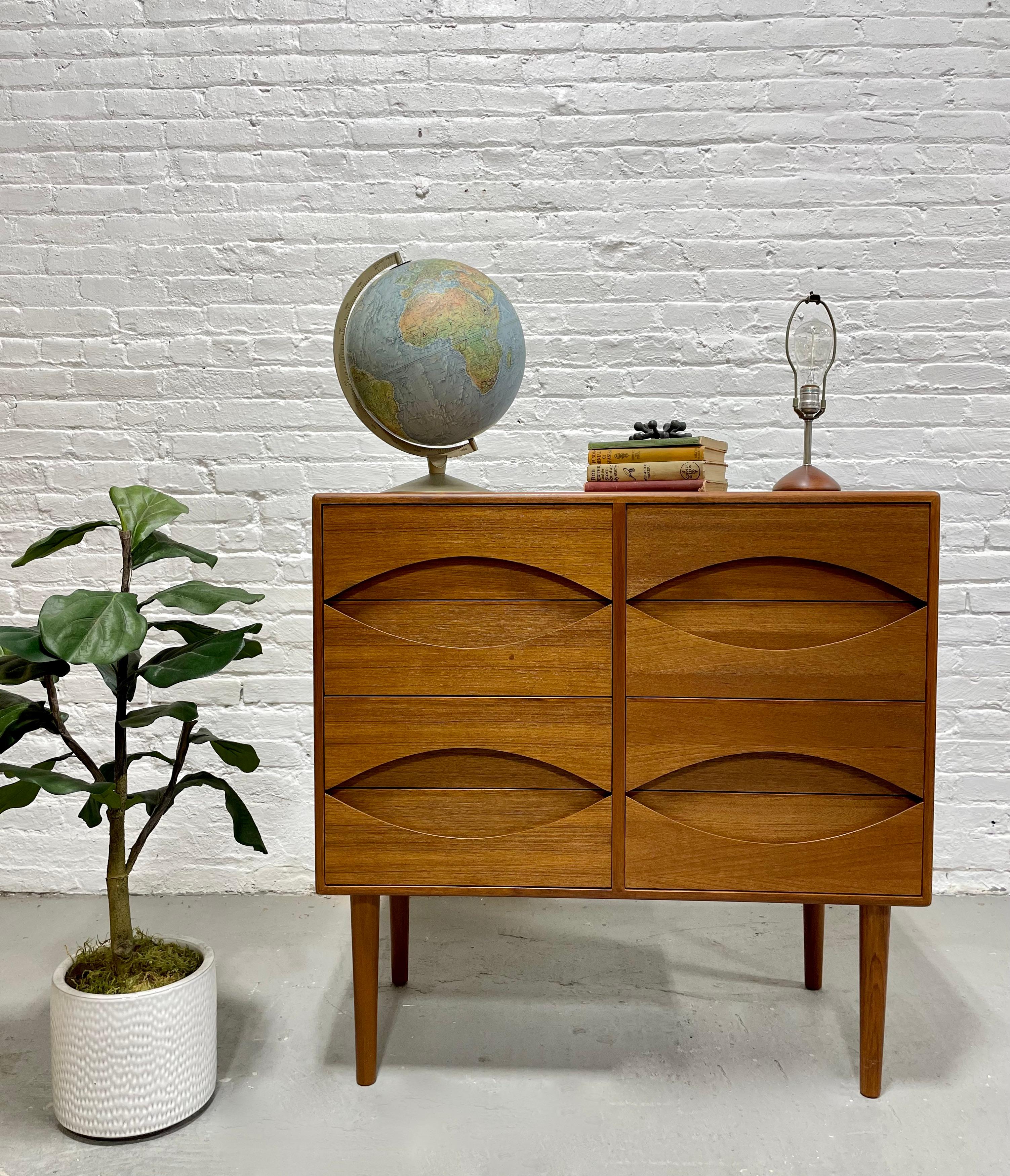 Exceptional Mid-Century Modern styled Teak Handcrafted dresser with eight drawers. Easy to open curved drawer pulls and long tapered legs. Gorgeous wood grains. Perfect as a bedroom dresser, nursery or entryway cabinet. Finished back.