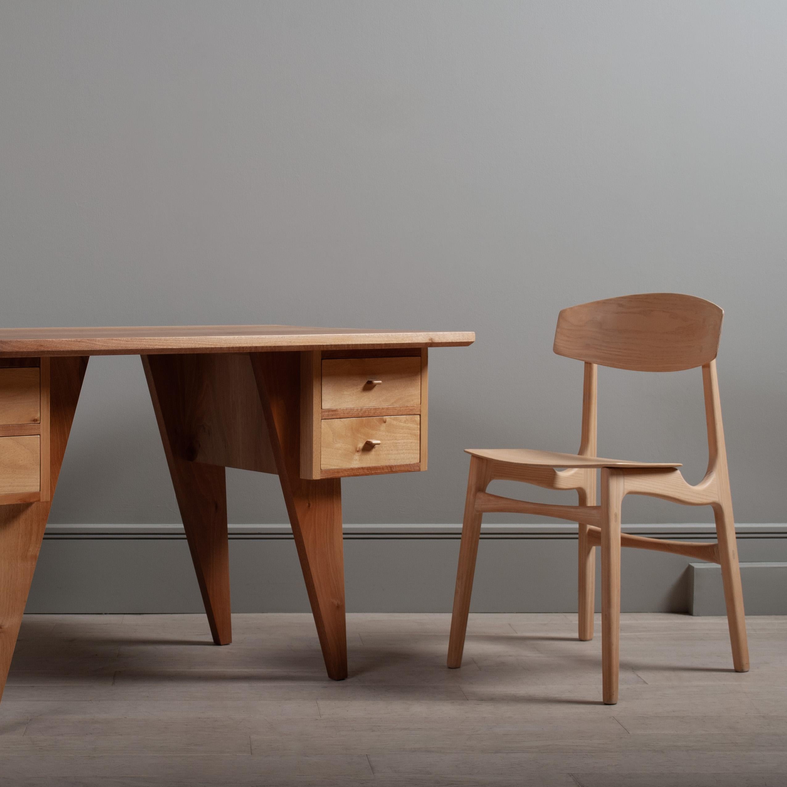 A totally unique handcrafted modernist desk designed and made in England by our craftspeople using traditional woodworking and cabinetry techniques. The beautifully figured surface is created using extra wide solid English walnut boards. The