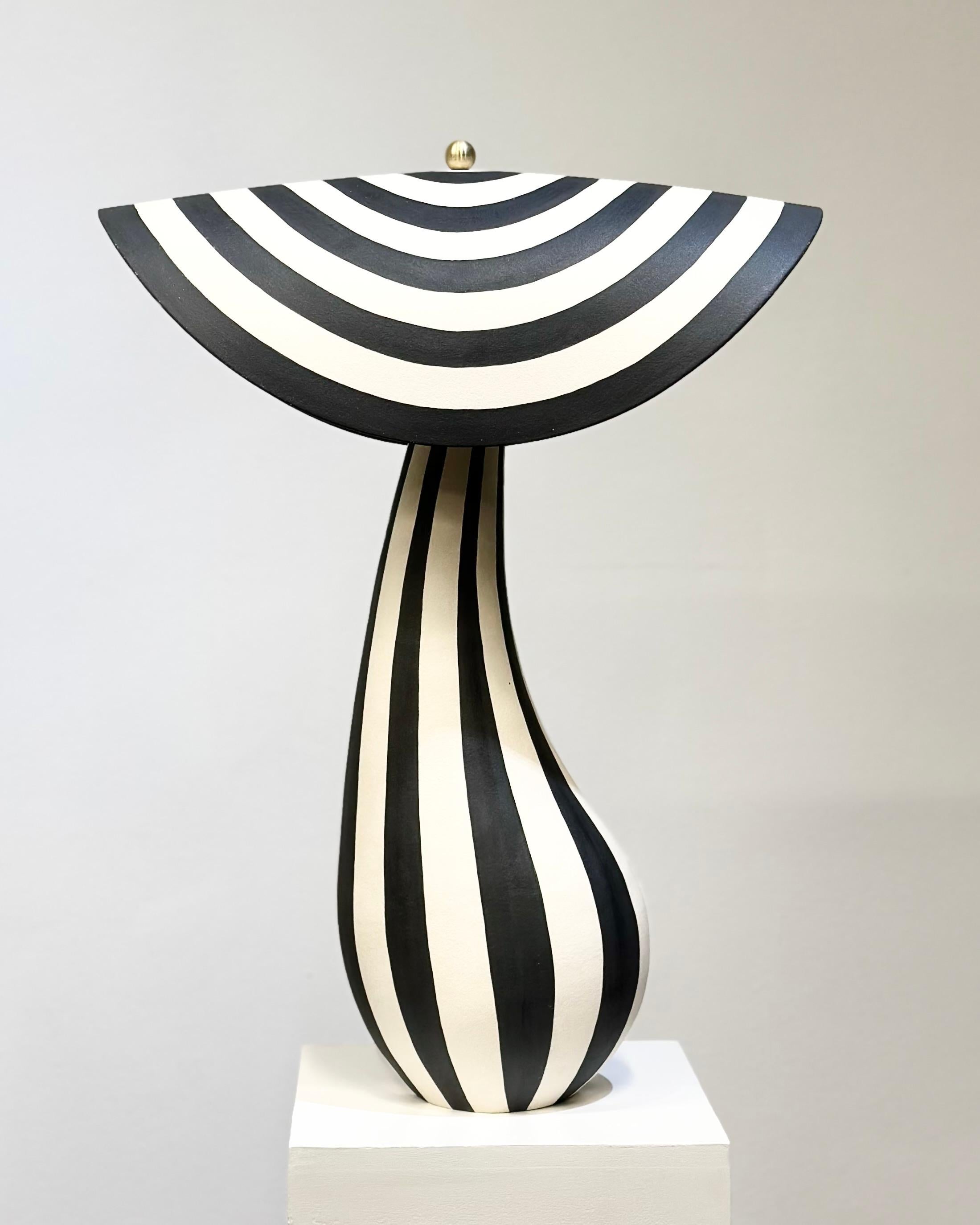 Lampe de bureau fabriquée à la main par l'artiste céramiste norvégien Johanne Birkeland, alias Jossolini.   

Cette pièce unique se compose de deux parties : une base de lampe en céramique et un abat-jour en céramique. Tous deux sont construits et