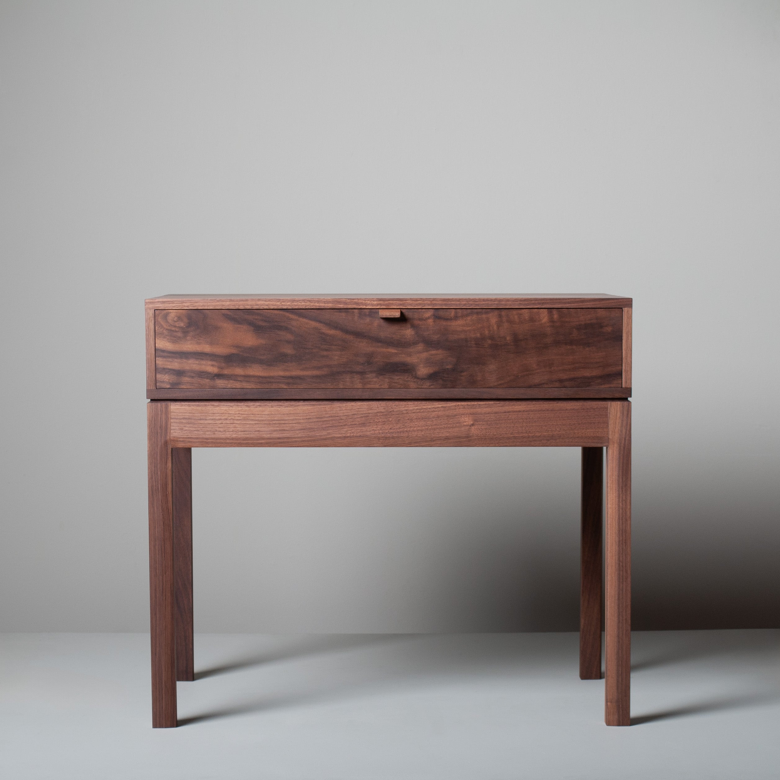 An American black walnut and English oak hand-crafted drawer table/nightstand/end table in a modernist design. These are constructed from the finest American black walnut with the inner dovetailed jointed traditional drawer carcass in prime English