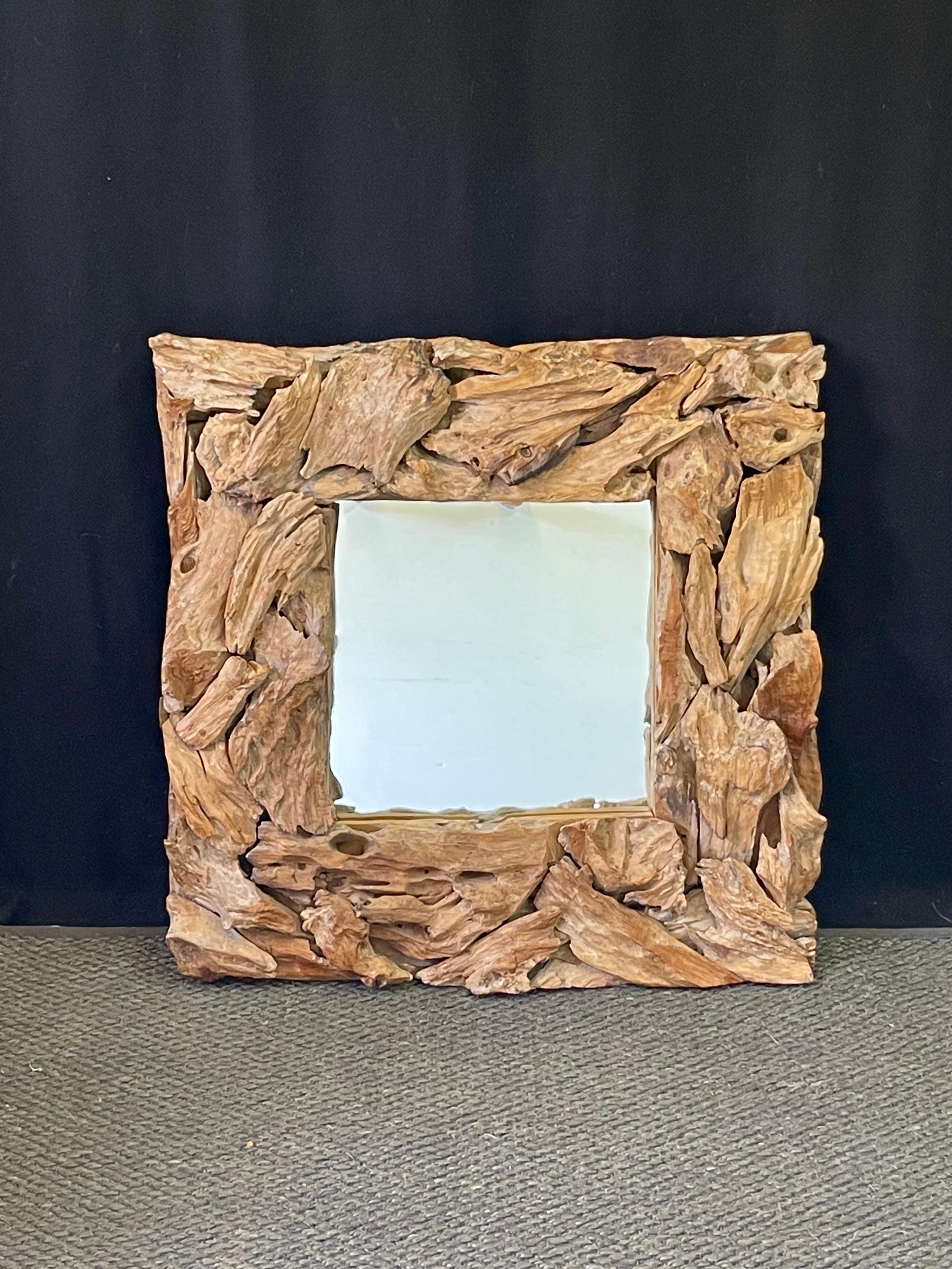 Cadre d'assemblage en bois flotté organique moderne du 20e siècle contenant un miroir. Des morceaux individuels de bois flotté ont été façonnés à la main pour former un cadre texturé, rustique et original, maintenu par un support en fer. 

Le