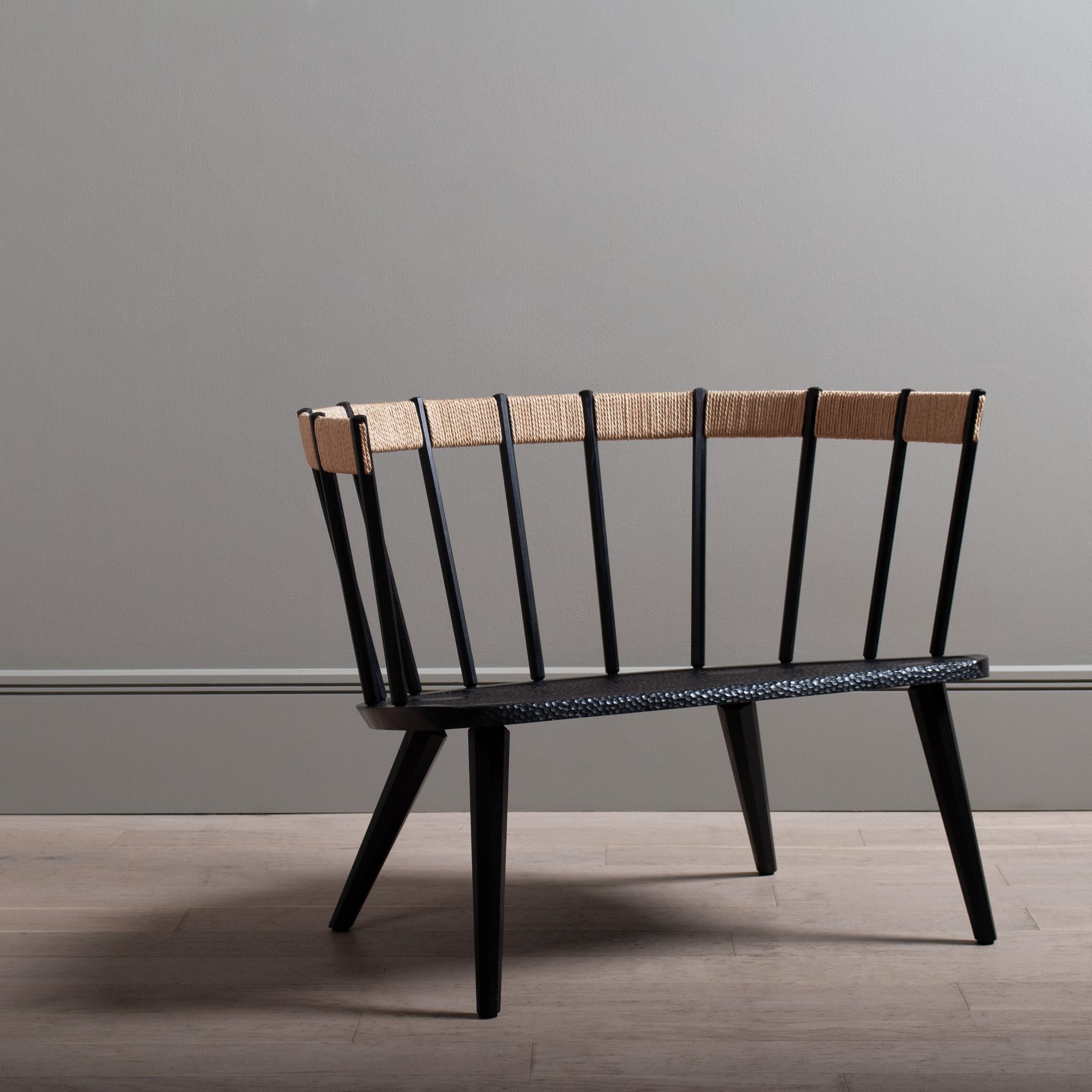 One of a kind English ebonised oak hand carved chair. 
A second iteration of this unique lounge chair by James Bowyer celebrating some of its Scandinavian ancestry with the seagrass woven back, tightly wound around a flexible timber core that gives