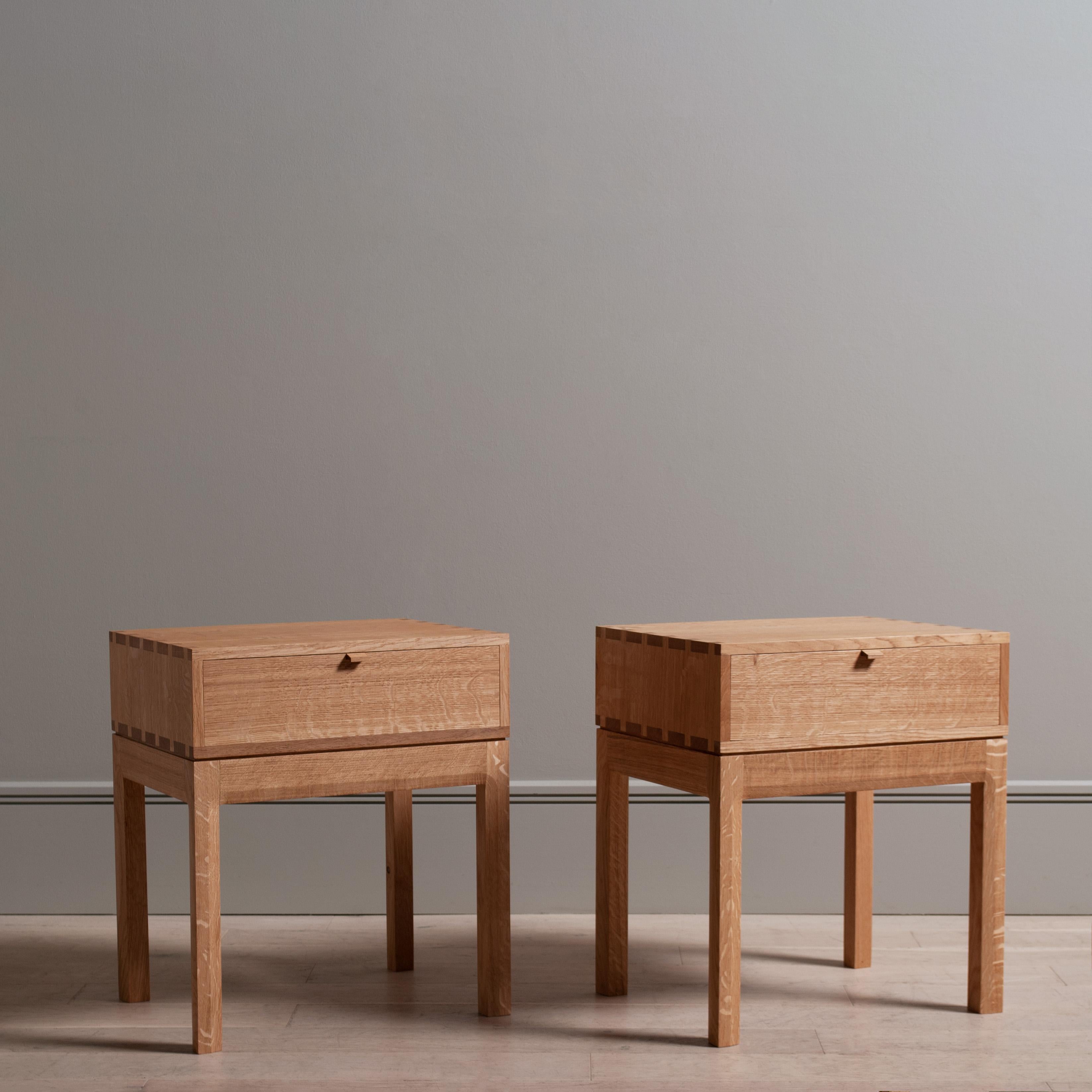 A pair of English quarter-sawn oak hand-crafted end tables in the modernist style. Constructed from finest English oak including all the internal dovetail jointed drawer and carcass. The upper box is detailed with exposed structural hand-cut