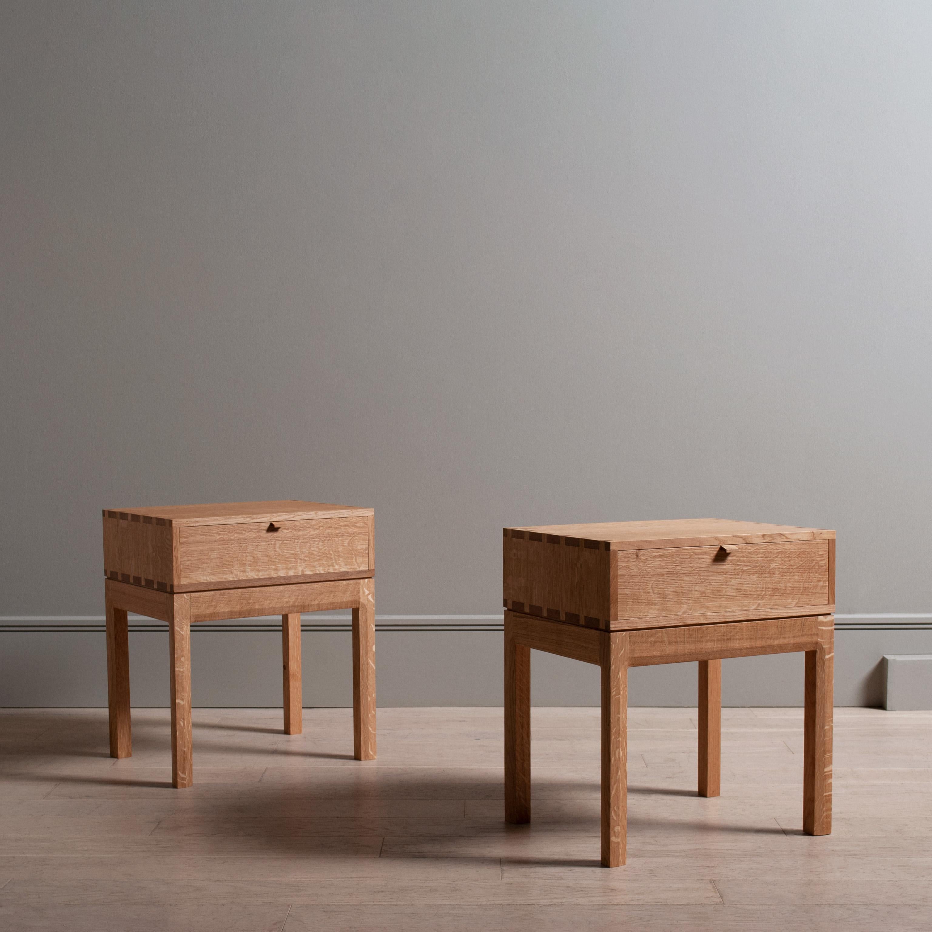 A pair of English quarter-sawn oak hand-crafted nightstands in the modernist style. Constructed from finest English oak including all the internal dovetail jointed drawer and carcass. The upper box is detailed with exposed structural hand-cut