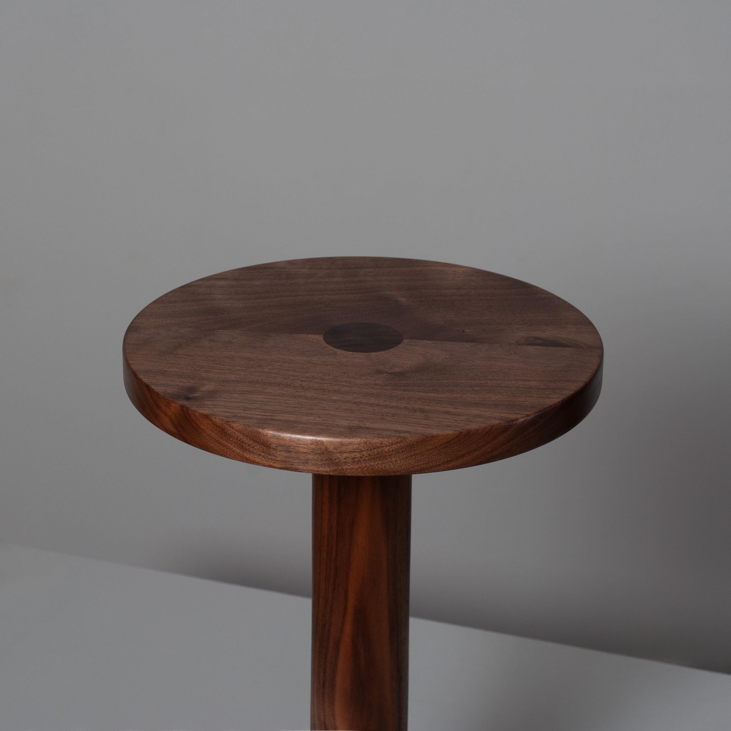 Bellissimo tavolino inglese in noce tornito e lavorato a mano. La base rotonda sale fino alla spessa colonna, che si apre sulla superficie superiore con un giunto passante visibile. Si tratta di un mobile audace e architettonico di alta qualità,