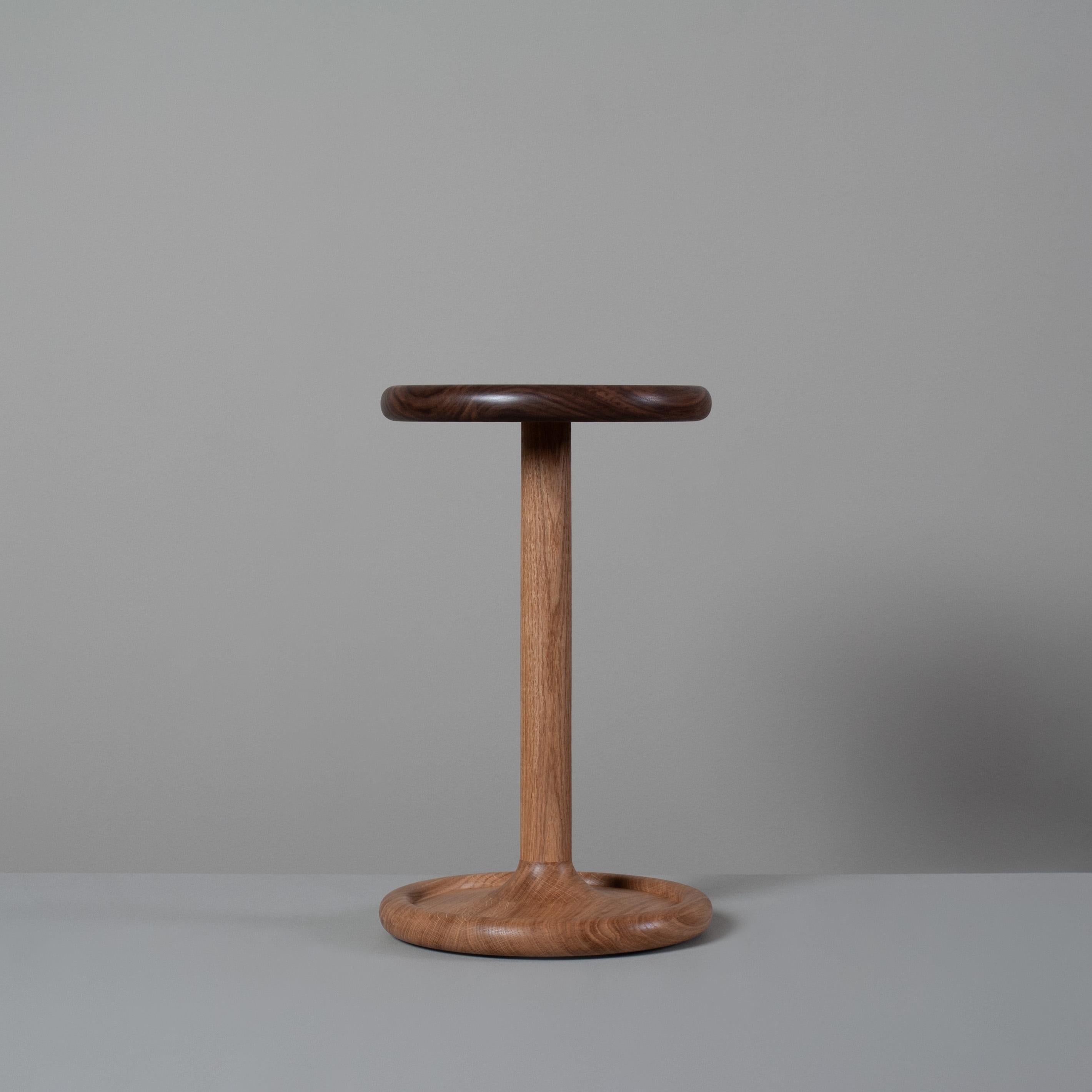 Beautifully hand-turned and handcrafted English oak and walnut side table. The top surface has a pillowed ripple turned underside and the base a superb cushion rounded rim taper ascending to the centre column. This is a bespoke piece of fine