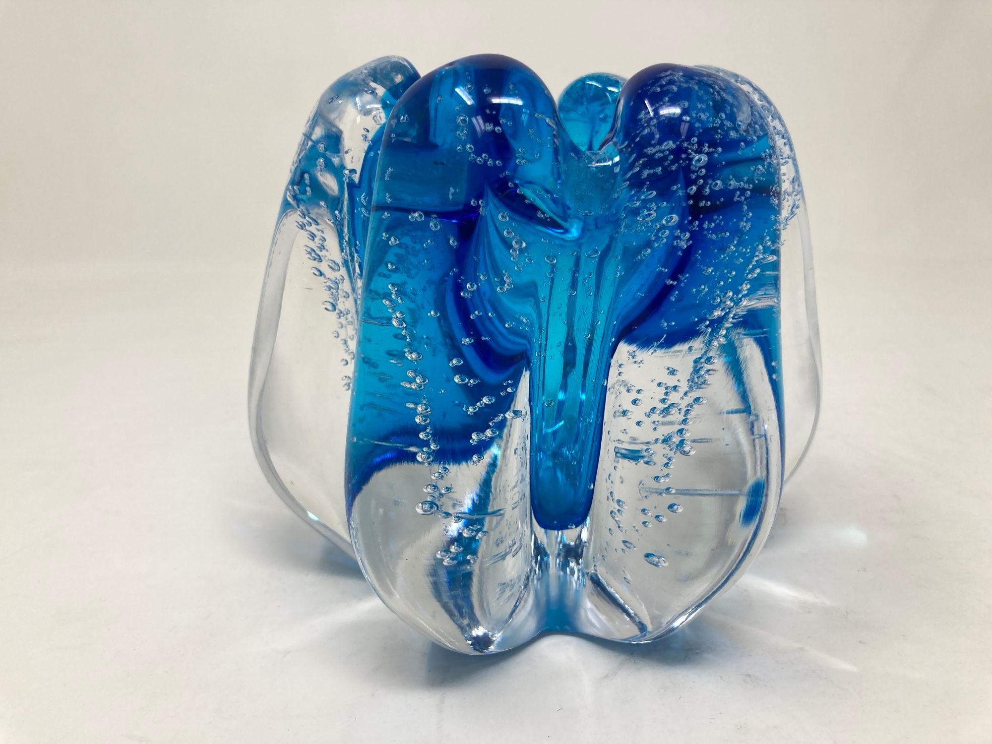 Beautiful handcrafted controlled bubble floriform clear cased art glass vase or votive or paperweight.
Beautiful Bohemian blue blown glass small vase or candle holder made in heavy thick art glass in a ruffled tulip shape.
This large votive or vase