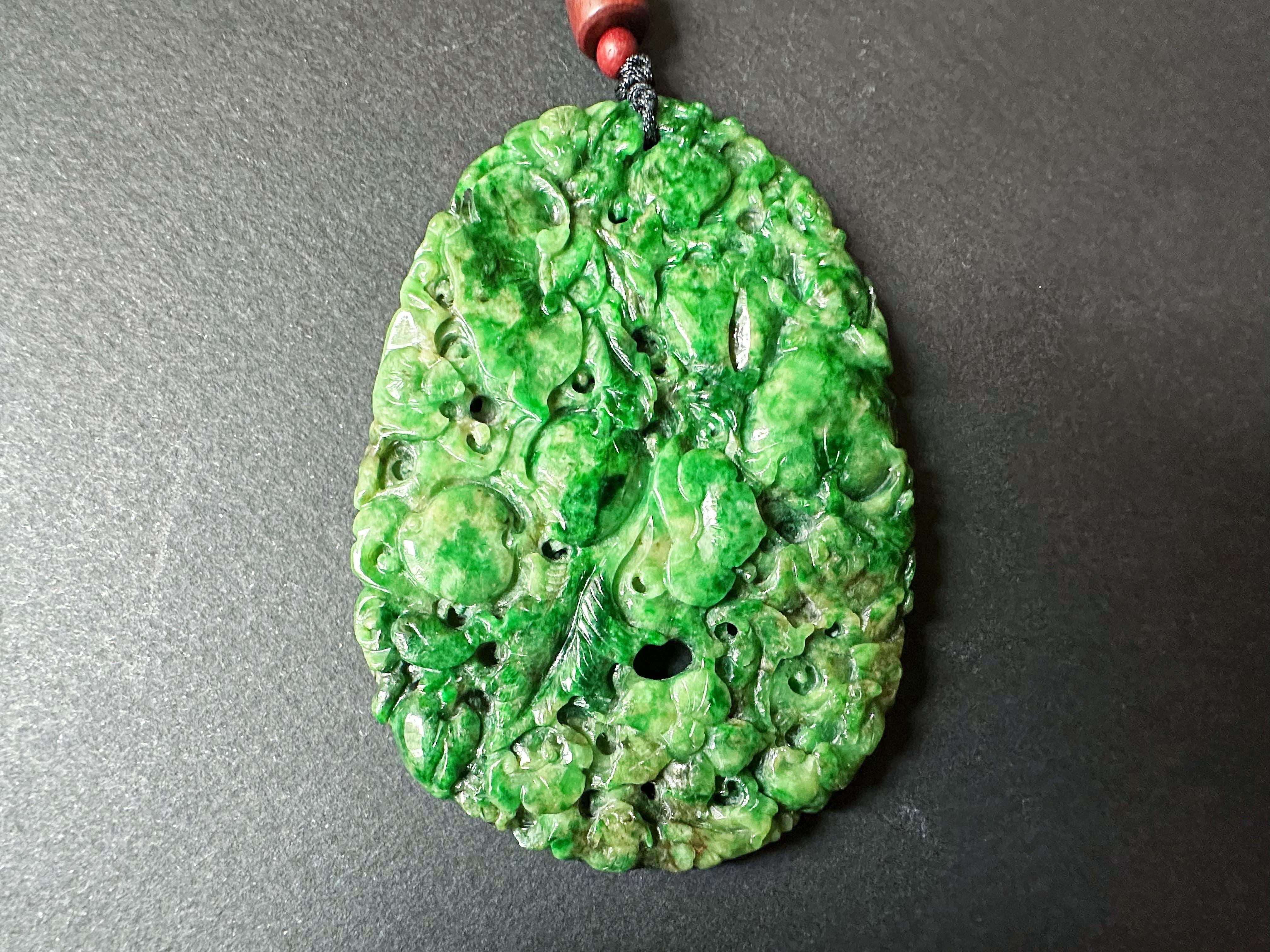 Rehaussez votre collection de bijoux avec notre superbe pendentif géant en jade vert intense, méticuleusement sculpté à la main. Cette pièce exquise présente des motifs complexes du Ruyi, symbole de bonne fortune et de pouvoir, de la pêche, qui