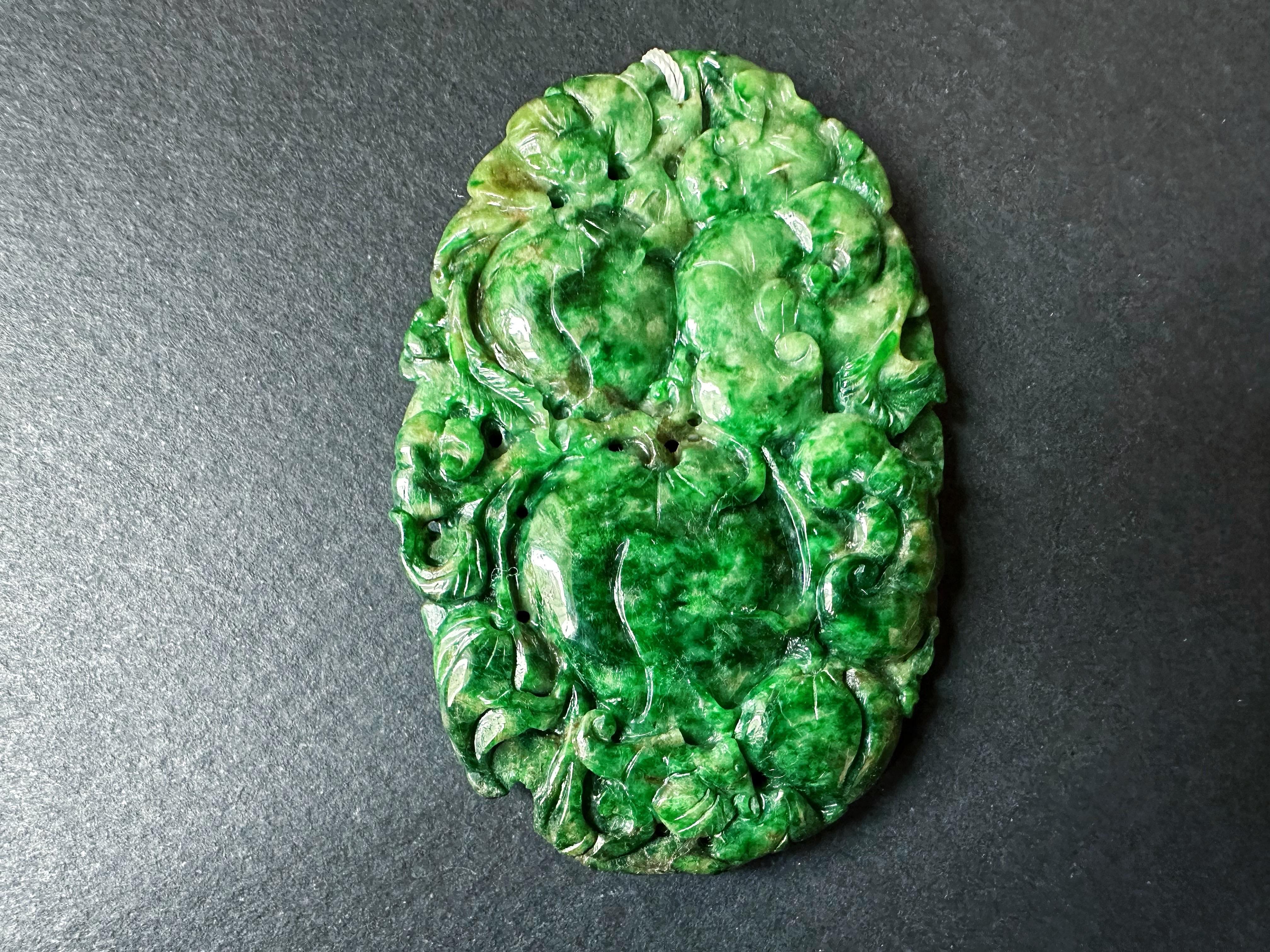 Rehaussez votre collection de bijoux avec notre superbe pendentif géant en jade vert intense, méticuleusement sculpté à la main. Cette pièce exquise présente des motifs complexes du Ruyi, symbole de bonne fortune et de pouvoir, de la pêche, qui