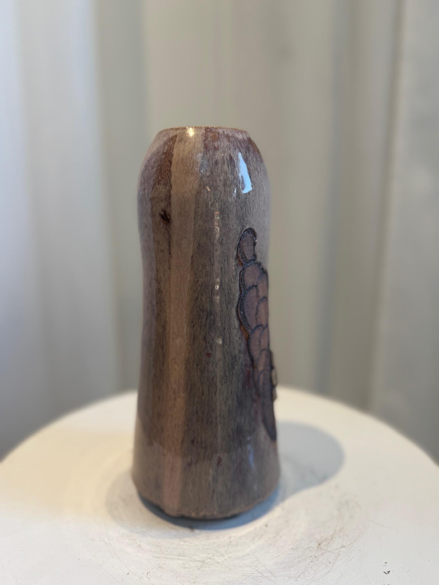 This elegant handcrafted studio pottery vase is a captivating example of mid-century ceramic artistry, blending rustic charm with refined craftsmanship. Its gently undulating form is both organic and deliberate, exuding the tactile authenticity that