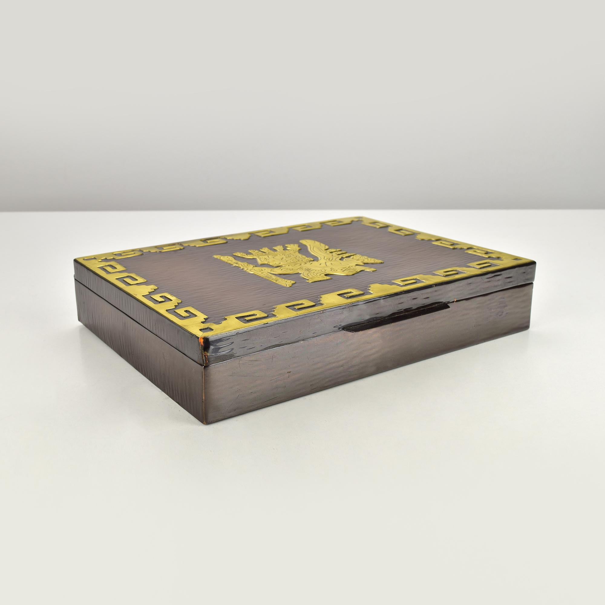 A striking blend of craftsmanship and cultural heritage, this vintage jewelry box from Peru captures attention with its bold design and sturdy build. Crafted from heavy copper, the box showcases a textured surface complemented by intricate brass