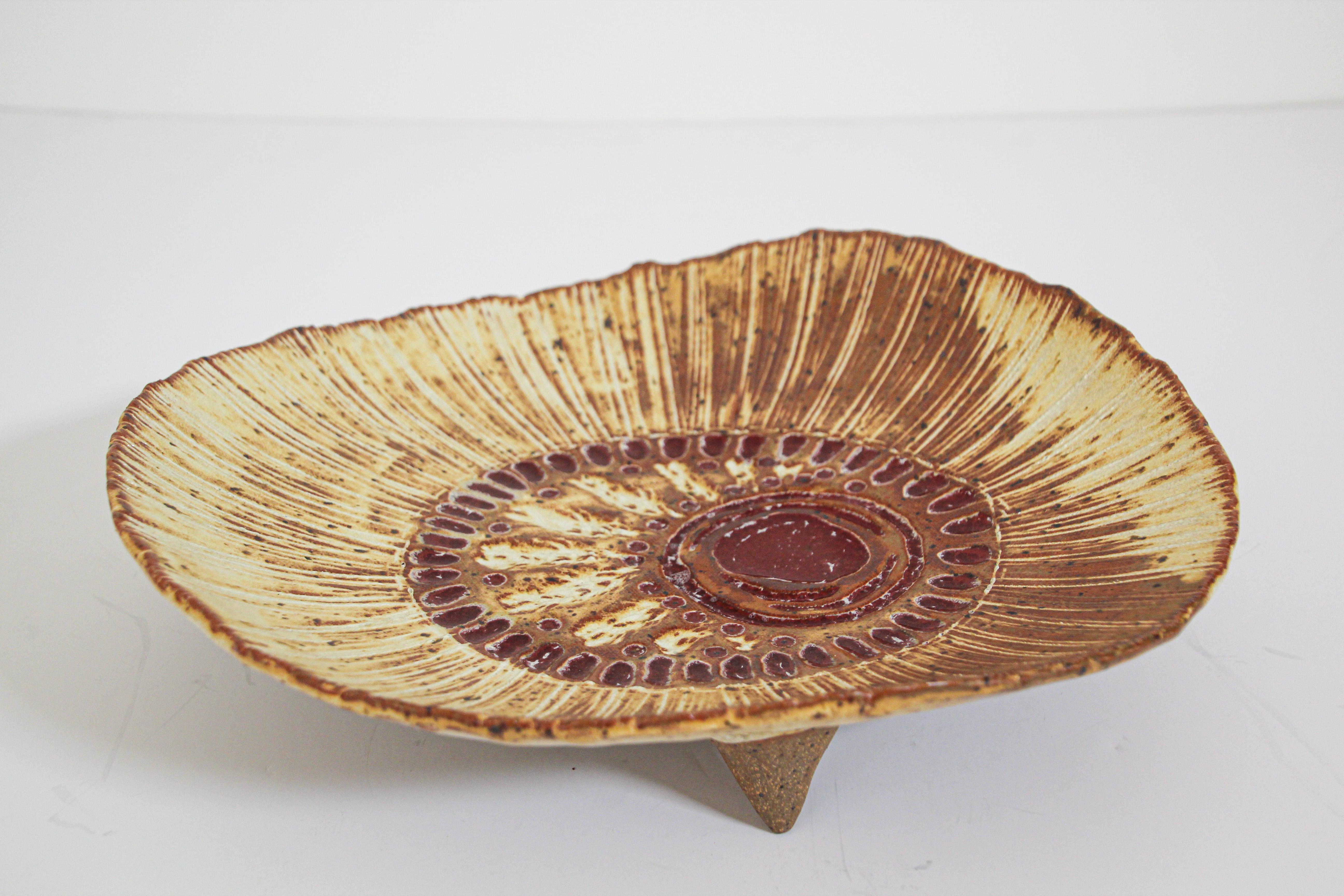 1960s Mid-Century Modern handcrafted and hand-decorated large Freeform footed plate.
Hand-painted stoneware decorative plate with Classic sandy fat lava glaze.
This ceramics was known to collectors as 'fat lava' and were made during the 1960s and