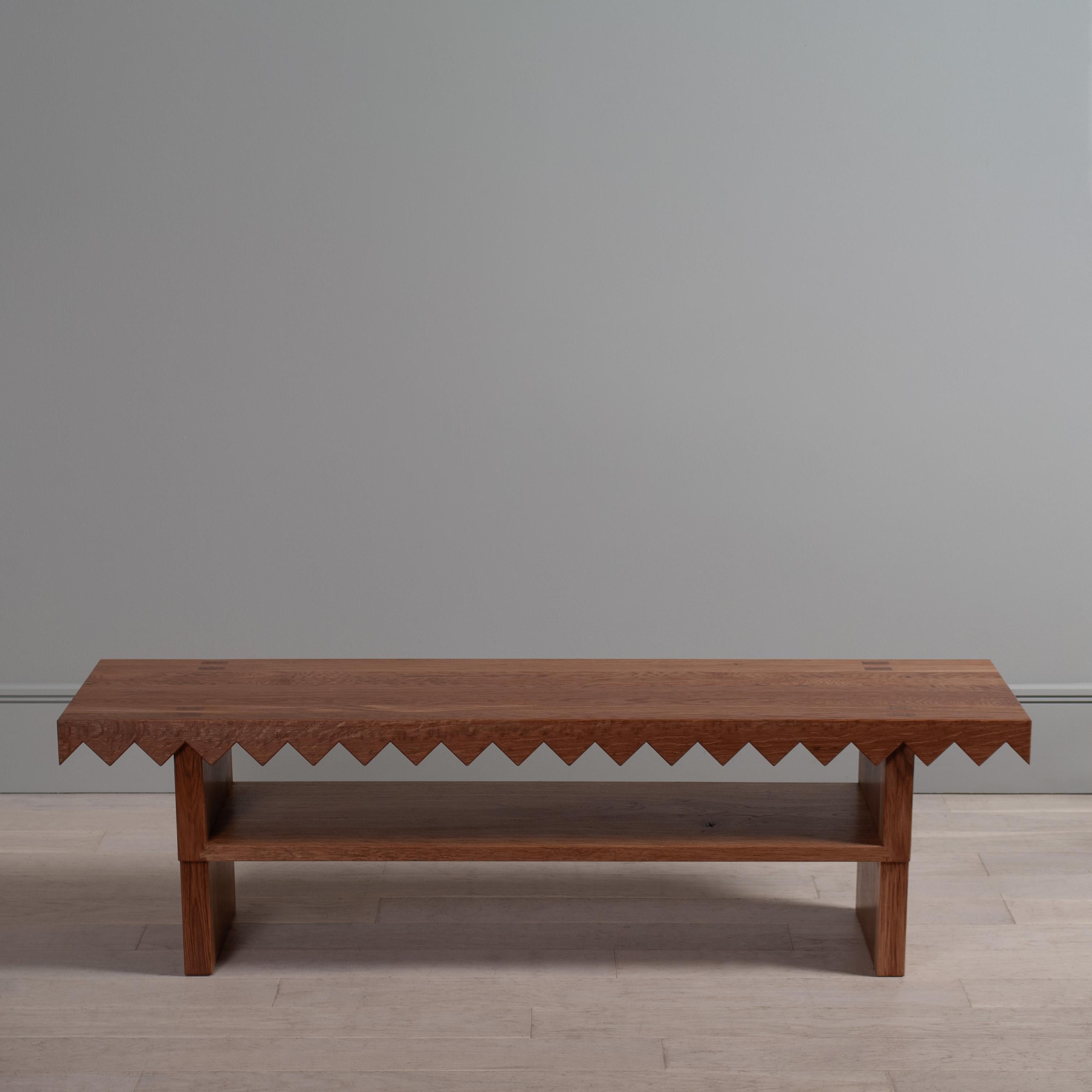 Large Sawtooth Bench in European oak.
Handcrafted in solid English oak this bench has an elegant, imposing and robust design.

The solid seat has a very bold sawtooth relief cut into it, and features precisely hand cut, wedged mortise and tenon