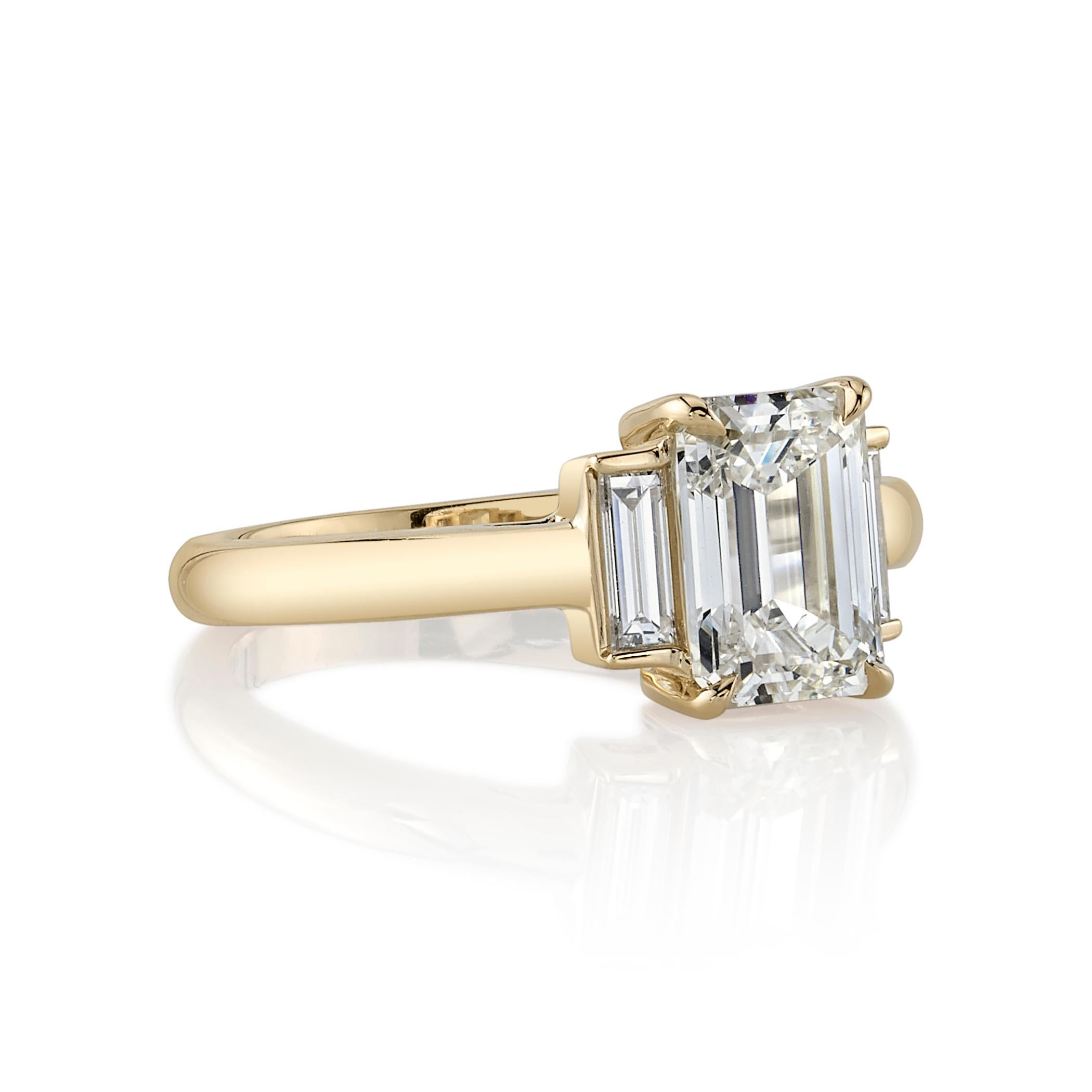 1.72ct M/VVS1 GIA certified emerald cut diamond with 0.25ctw baguette cut accent diamonds set in a handcrafted 18K yellow gold mounting.
