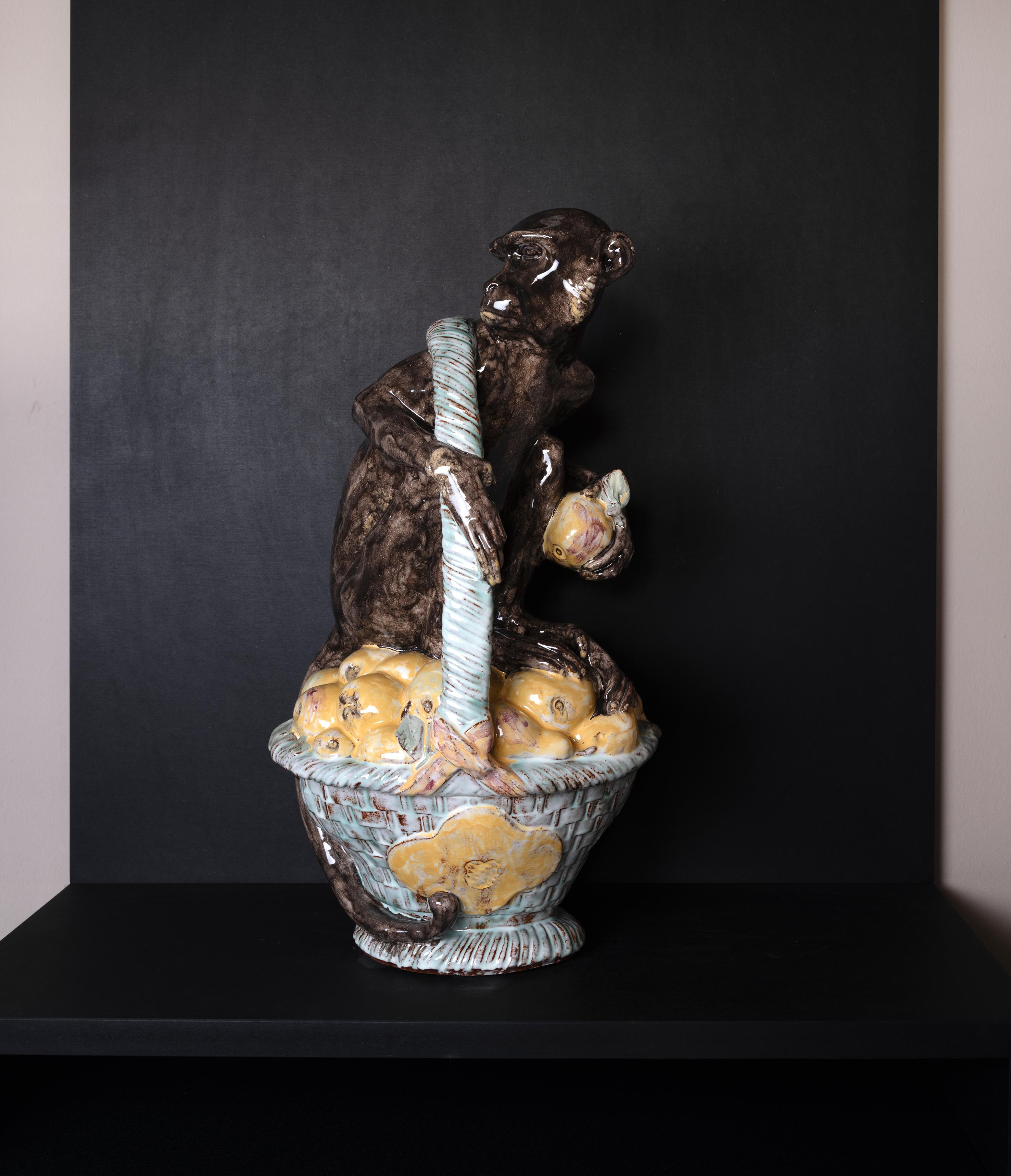 Esta figura de un mono sentado en una cesta de fruta es un maravilloso ejemplo de las habilidades escultóricas de Josef Wackerle. El personaje del mono, sentado y preparado para lanzar la fruta, es humorístico y está lleno de la tensión del momento.