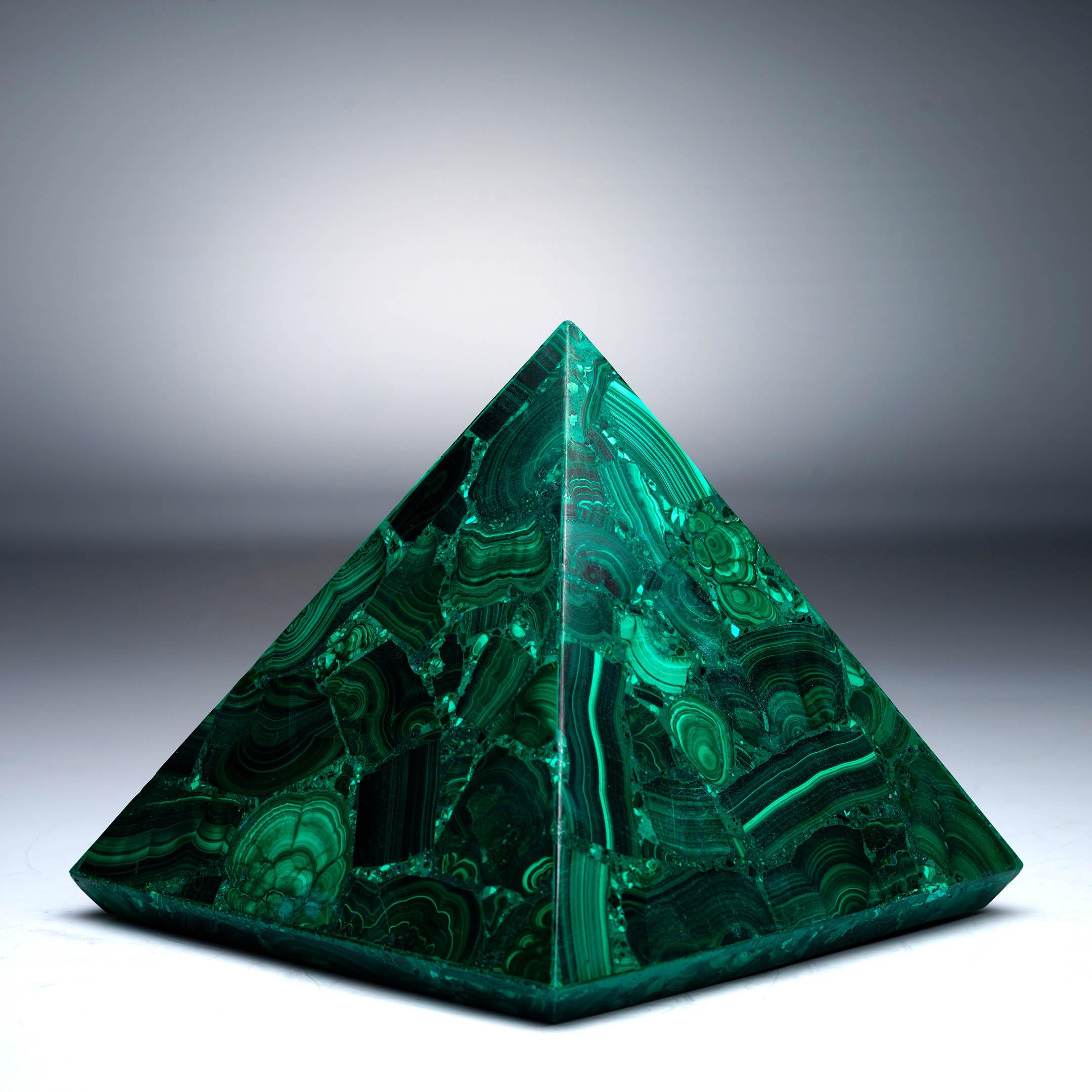 Esta extraordinaria pirámide de malaquita tallada a mano resalta el arte natural de la piedra en una refinada forma geométrica. Elaborada con malaquita auténtica, la escultura muestra las características bandas del mineral en tonos vivos que van del