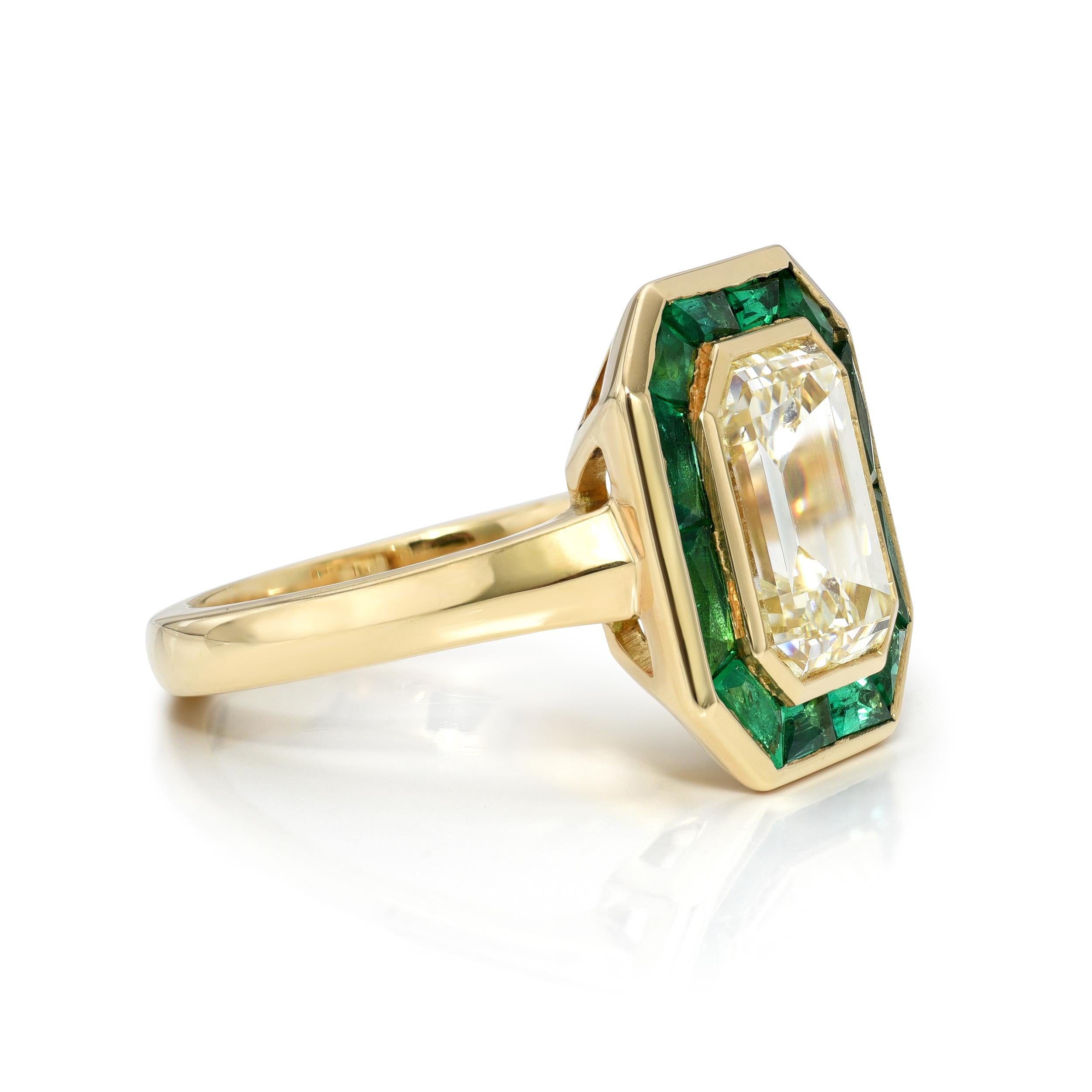 3.46ct N/VS2 GIA certified emerald cut diamond with 0.94ctw French cut green emerald baguette accent stones bezel set in a handcrafted 18K yellow gold mounting. 