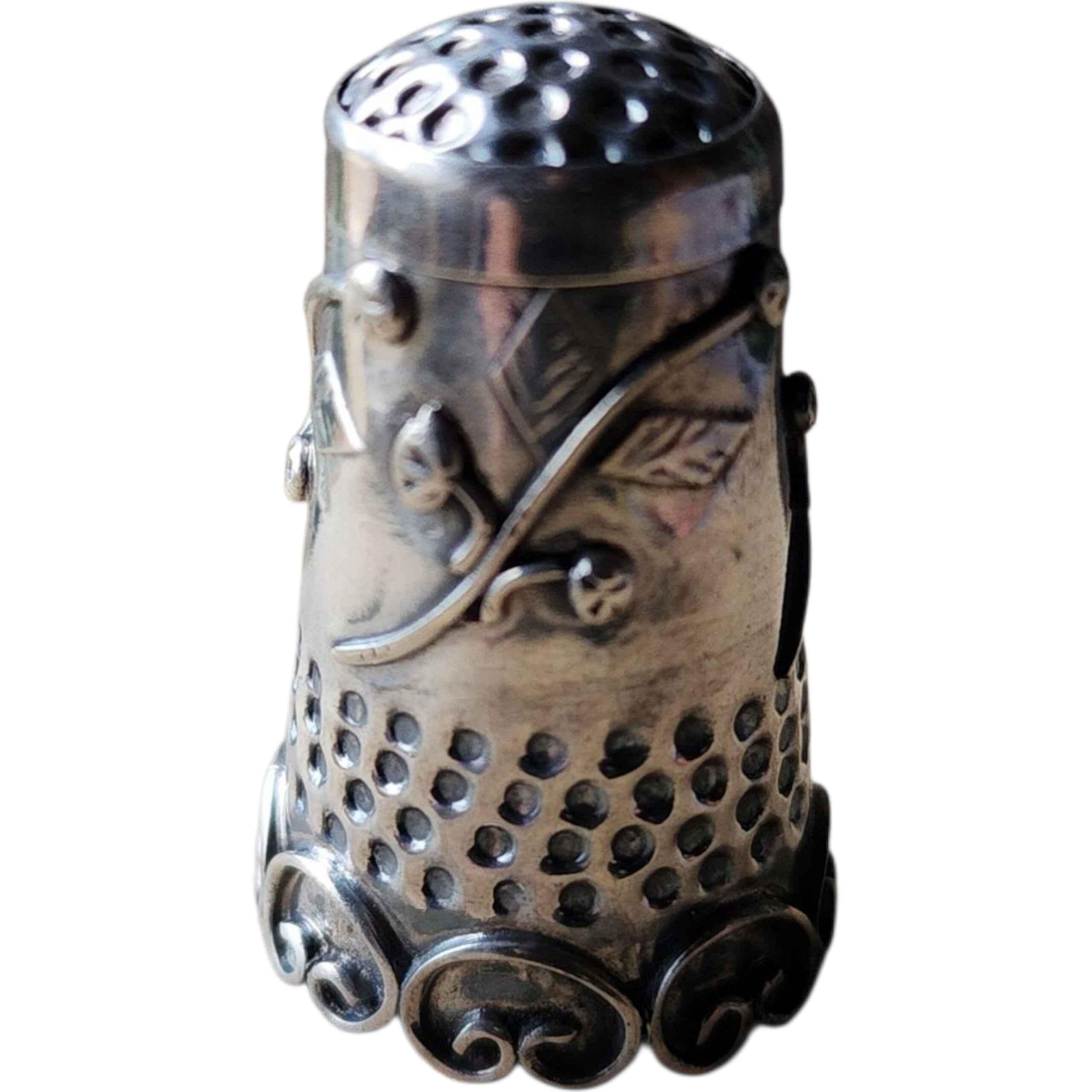 Ditale antico in argento Sterling .925 con rilievi floreali e a volute - Oggetto da collezione per il cucito fatto a mano
Un'antica e dettagliata moneta d'argento .925.  ditale, con viti floreali applicate a mano, motivi di bacche in rilievo e un