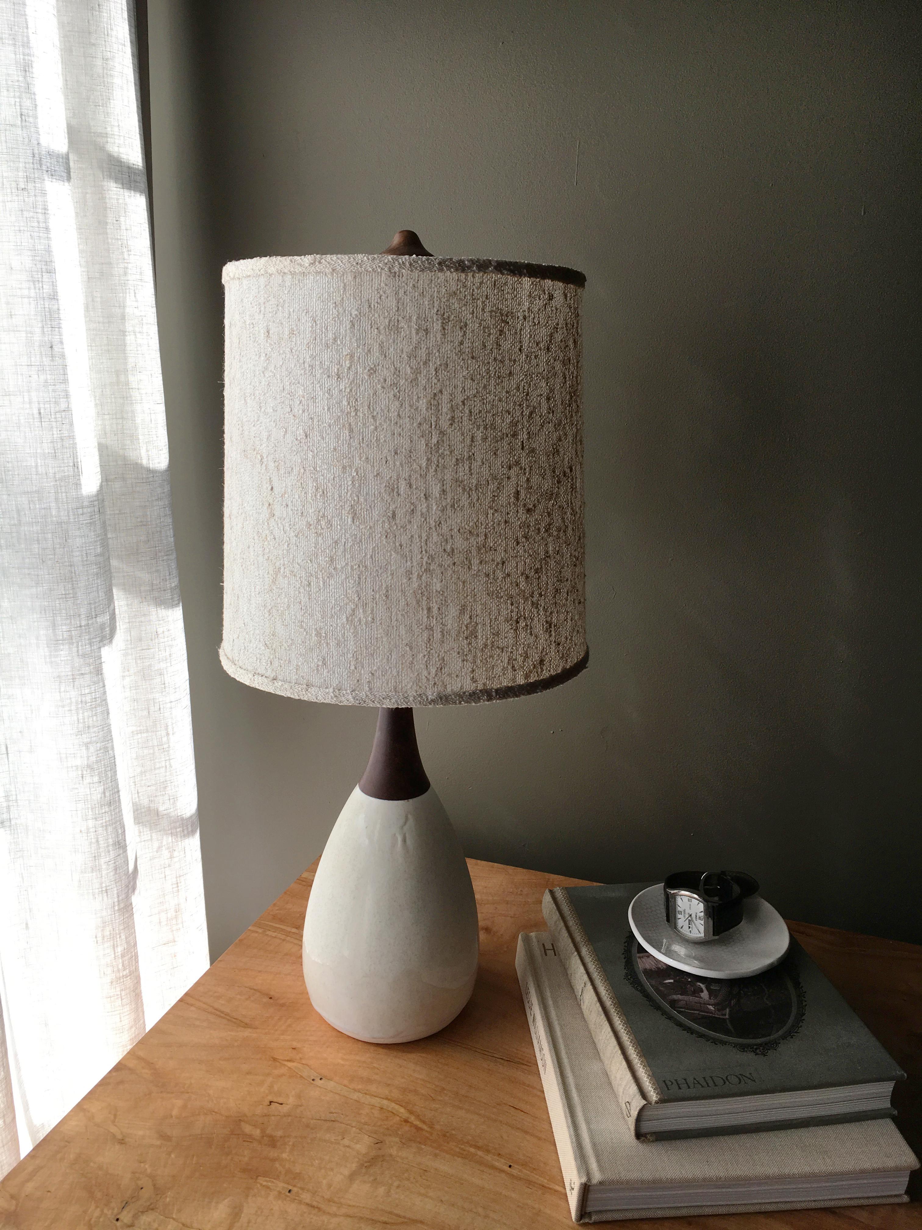Classic mid-century styling, Esther has a hand poured porcelain base with hand turned walnut neck and finial. The shade is made from a nubbly boucle. Nickel hardware, black cloth cord. Designed by Daniel Oates and Dana Brandwein in 2008. Handmade to