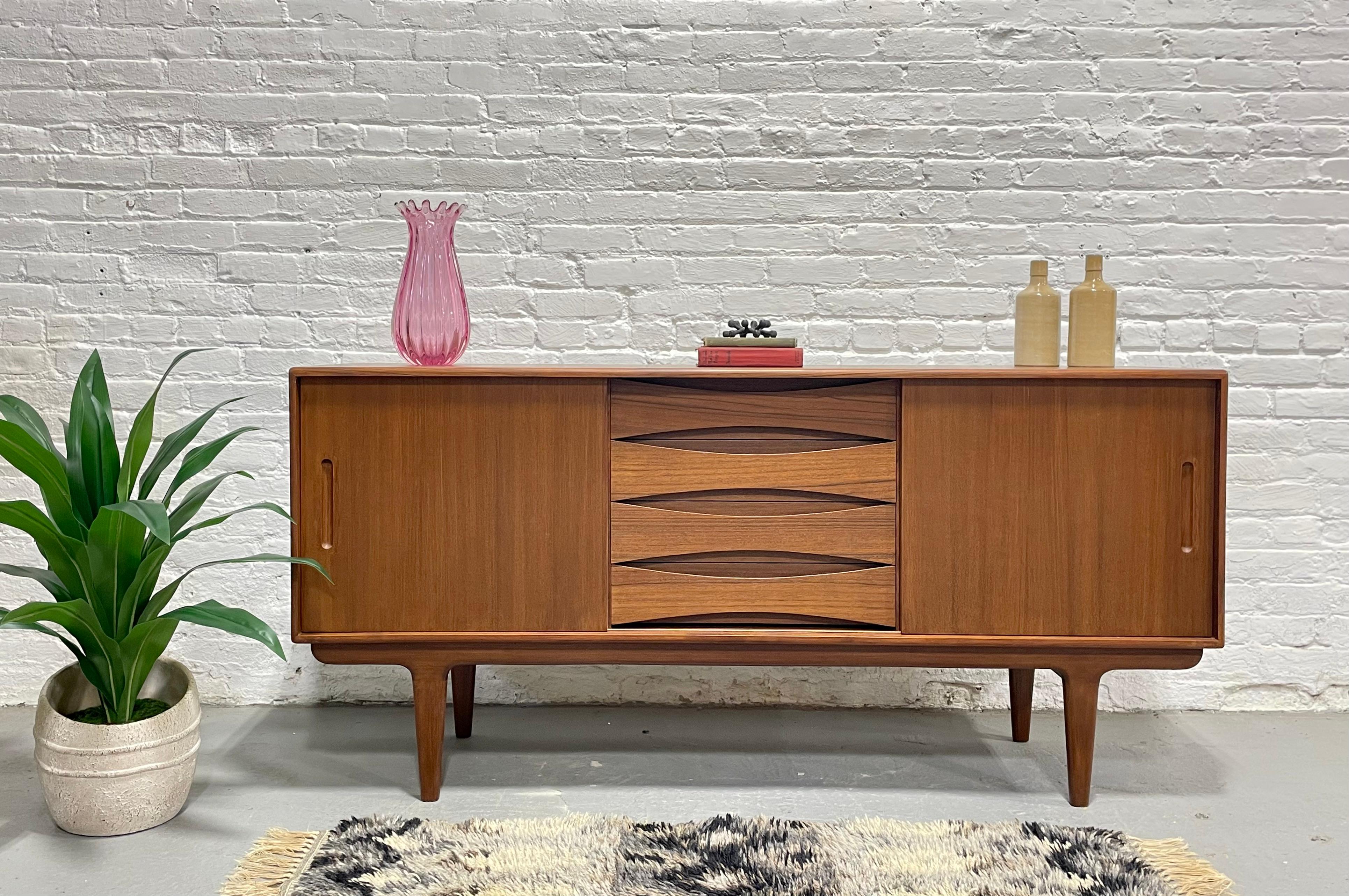 Une étonnante crédence en teck du milieu du siècle dernier qui met en valeur les lignes épurées et les proportions raffinées du design scandinave classique. Fabriquée à la main avec une attention méticuleuse aux détails, cette pièce polyvalente
