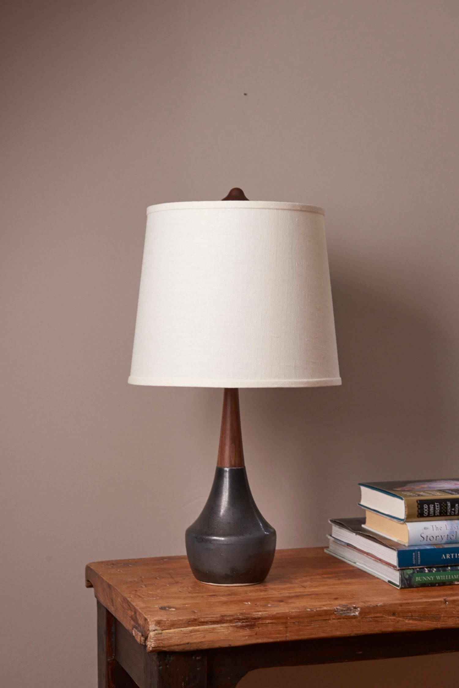 A nod to mid century modern styling, the Marilie Lamp has a small profile perfect for the bedside or desk. Each lamp is handmade to order in our Connecticut studio. It combines the smoothness of high quality porcelain with hand-turned walnut for the