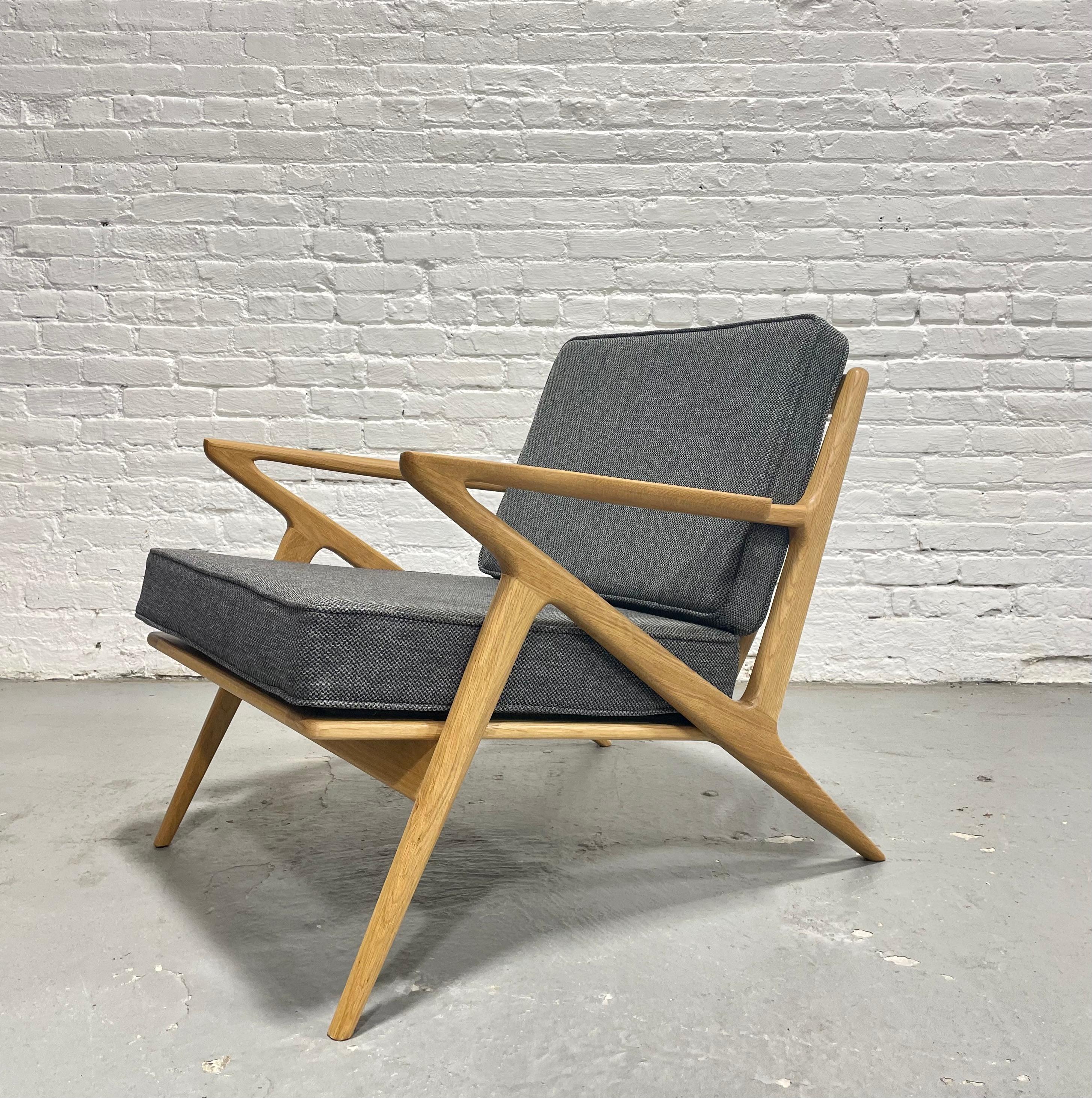 Chaise de salon de style moderne du milieu du siècle, méticuleusement fabriquée à la main en chêne massif, mettant en valeur un design et un savoir-faire intemporels. Doté d'accoudoirs sculpturaux, de lattes de dossier triangulaires inclinées et