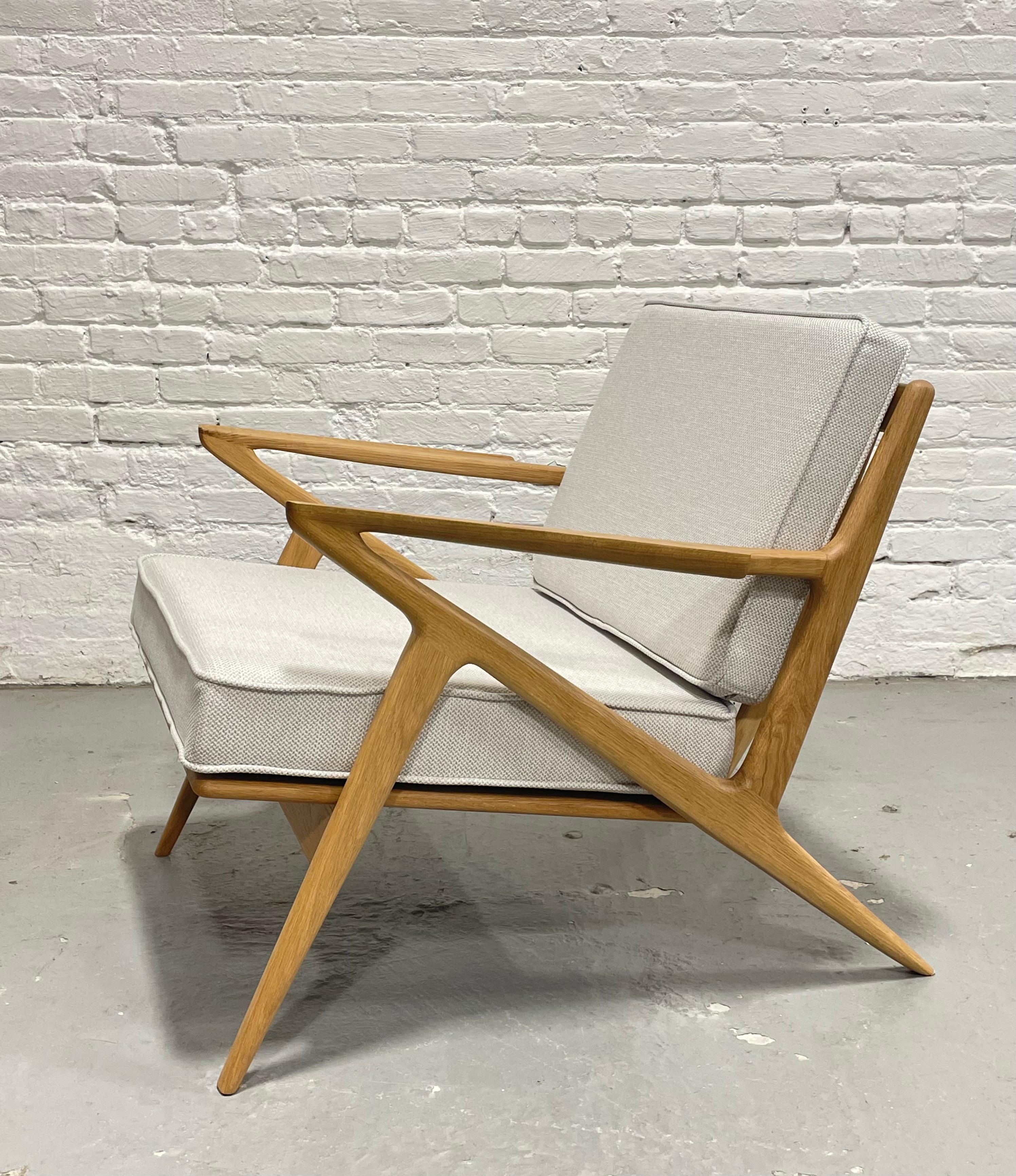 Chaise de salon de style moderne du milieu du siècle, méticuleusement fabriquée à la main en chêne massif, mettant en valeur un design et un savoir-faire intemporels. Doté d'accoudoirs sculpturaux, de lattes de dossier triangulaires inclinées et