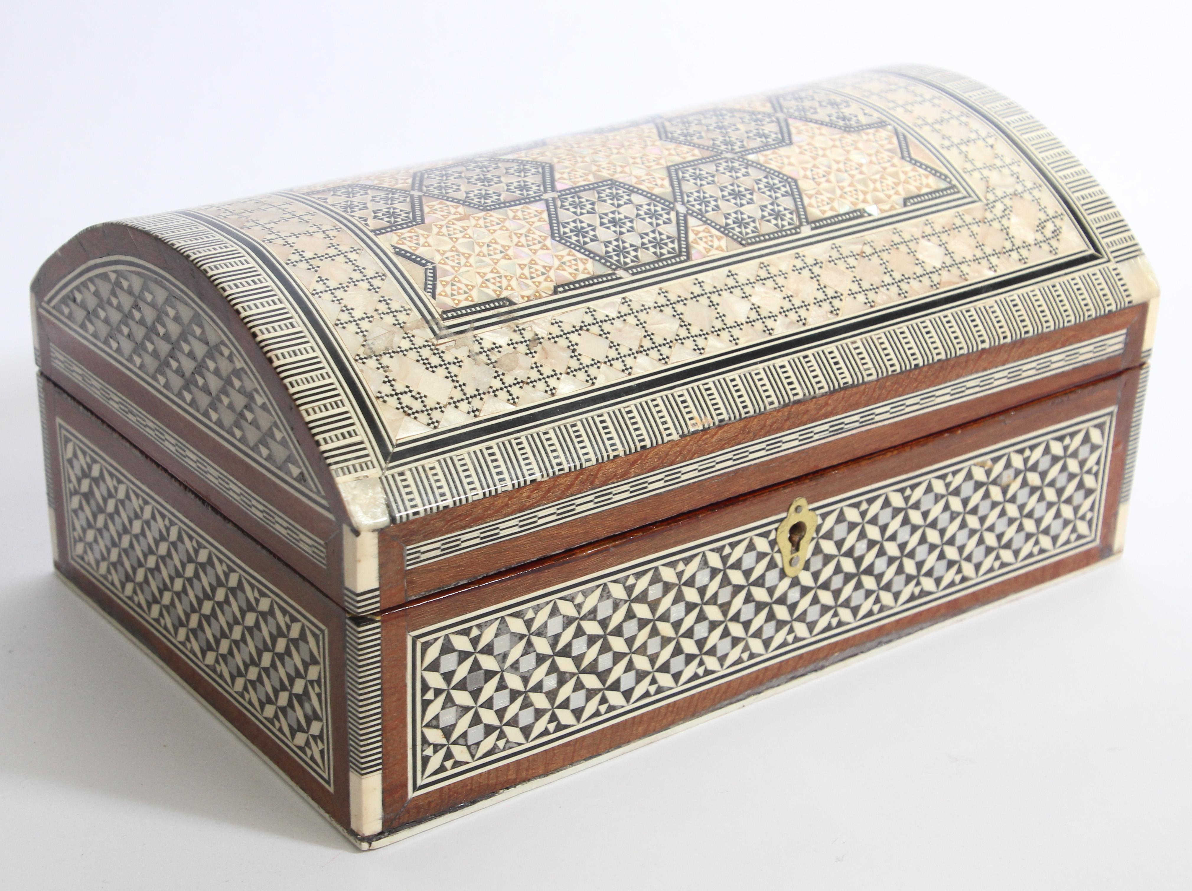 Große exquisite handgefertigte nahöstliche ägyptische Mosaik Einlegearbeit Sadeli Holz Schmuckkästchen.
Die Kuppeltruhe ist mit maurischen Motiven verziert, die sorgfältig in verschiedene Fruchthölzer eingelegt wurden.
Dekoratives Kästchen aus