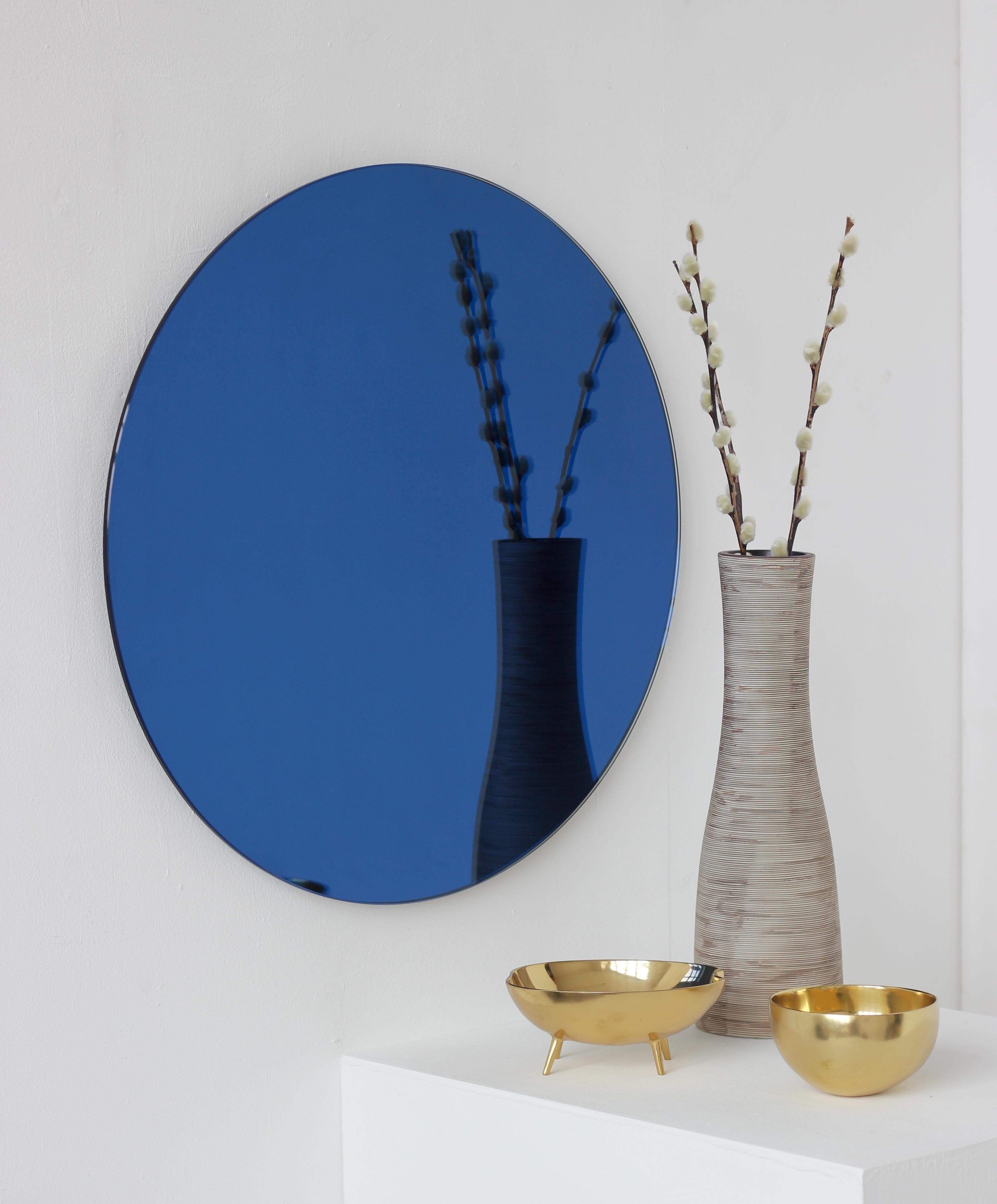 Charming and minimalist blue tinted round frameless mirror with a floating effect. Quality design that ensures the mirror sits perfectly parallel to the wall. Designed and made in London, UK.

Fitted with professional plates not visible once