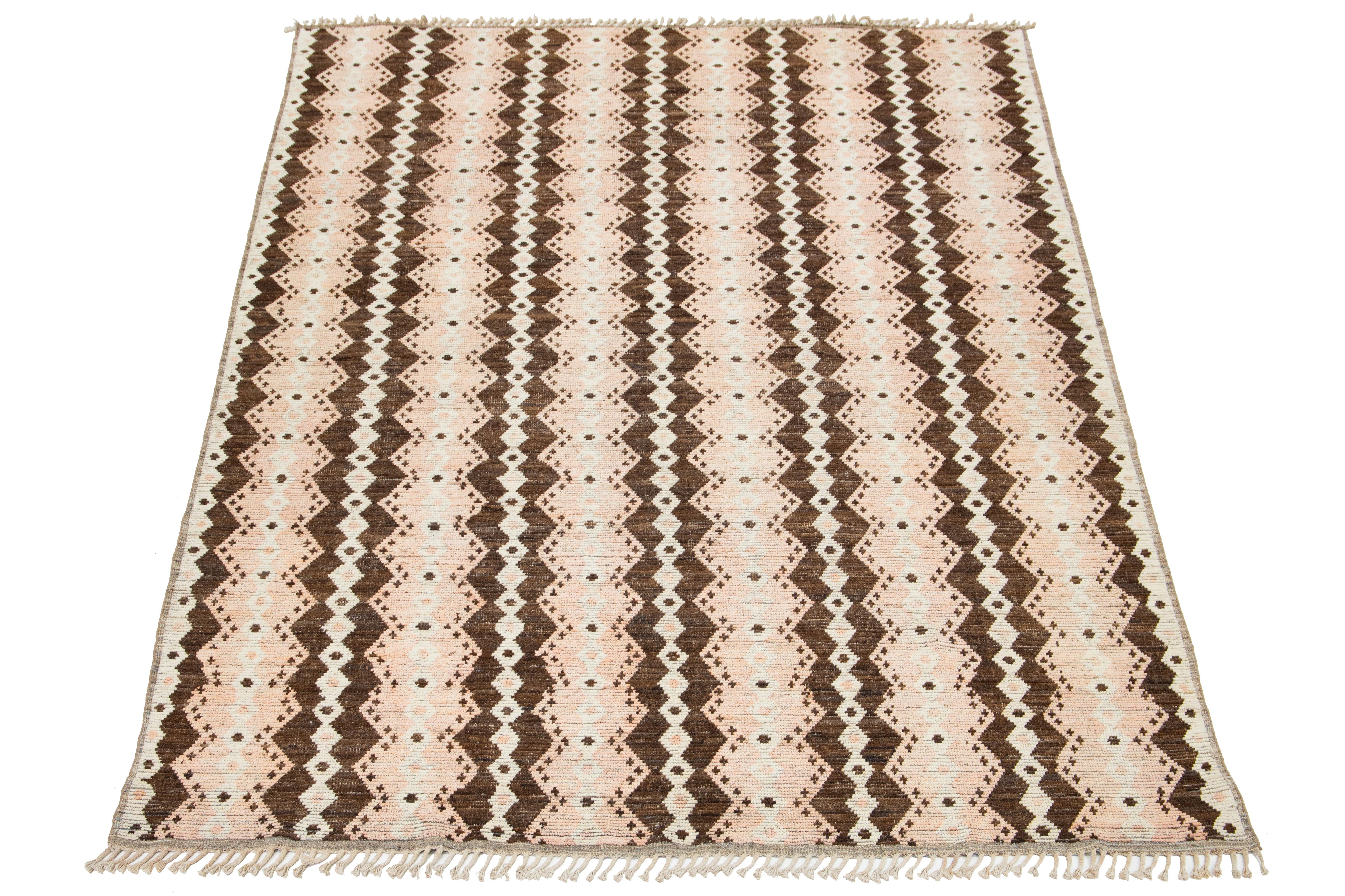 Rehaussez votre espace avec ce tapis fabriqué à la main dans un style marocain moderne. Fabriqué en laine de haute qualité, il arbore une texture douce qui ajoute de la chaleur à n'importe quelle pièce. Le design géométrique présente un mélange de
