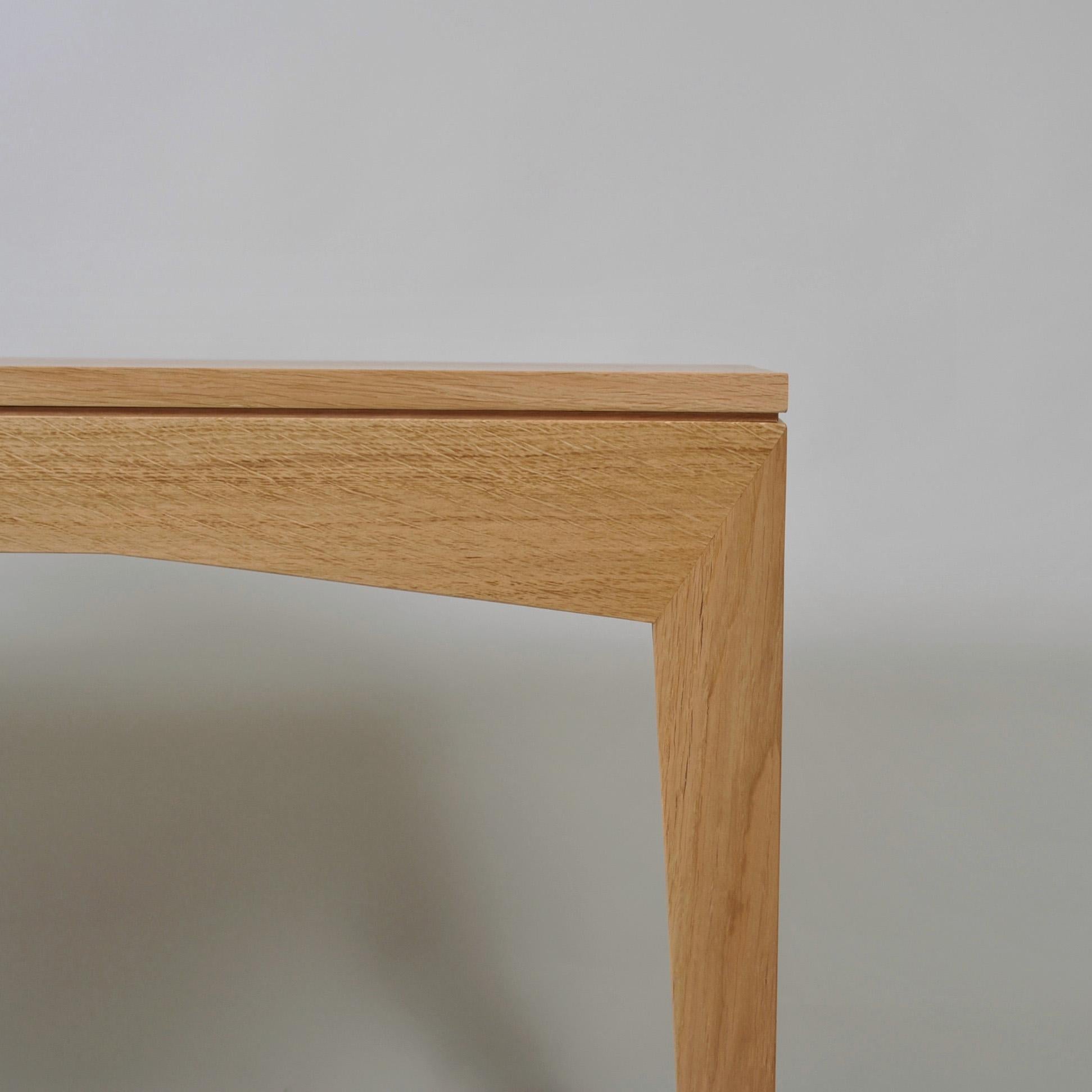 Un élégant bureau ou table d'écriture moderniste anglais fait à la main. Construit avec une surface traditionnelle de 3 planches solides sur des pieds et un cadre à angles aigus magnifiquement visibles. Fabriqué à la main par des artisans de