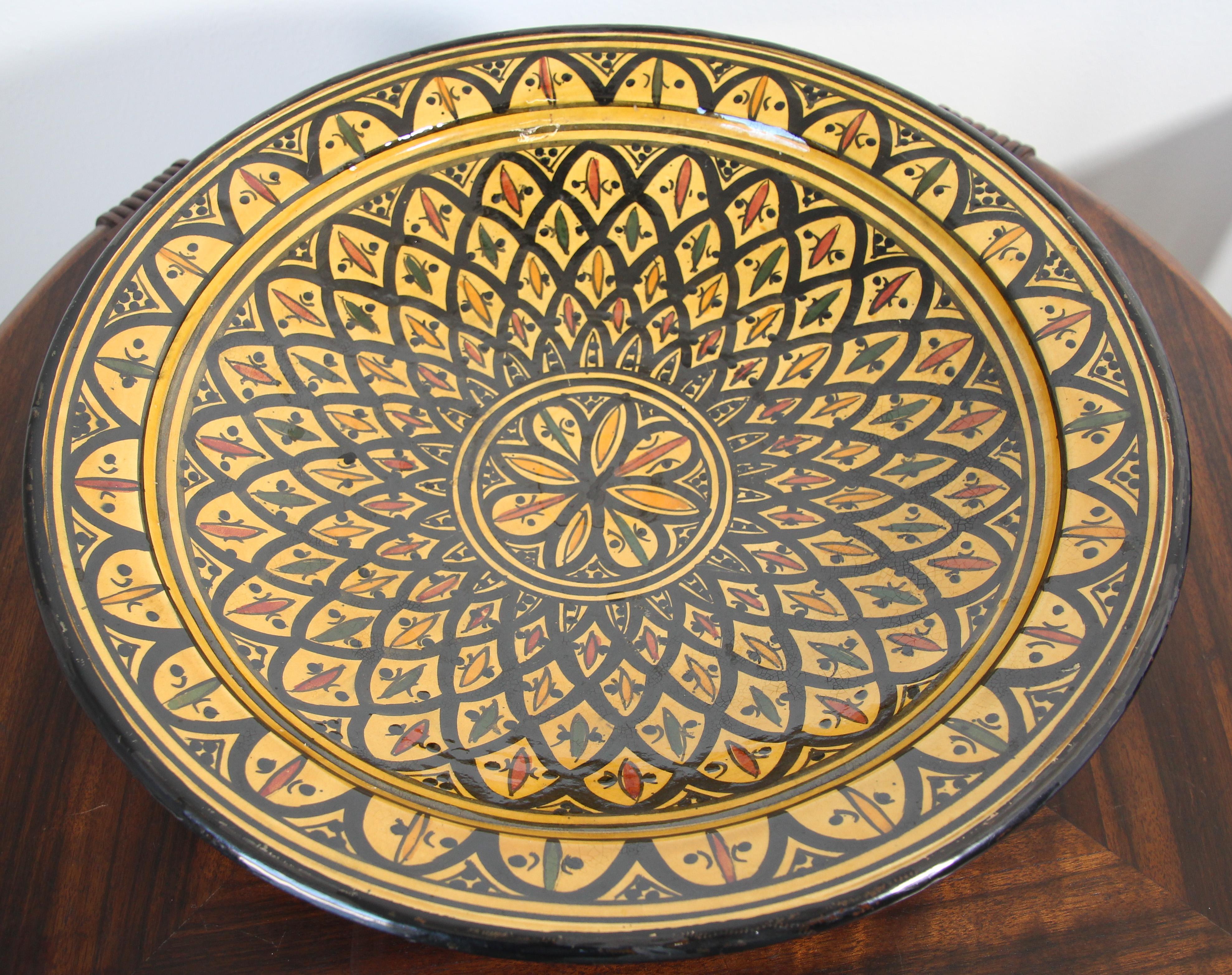 Handcrafted Moroccan hand-painted glazed ceramic plate with a yellow background and adorned with geometric black Moorish designs.
Signed in the back in Arabic “Safi