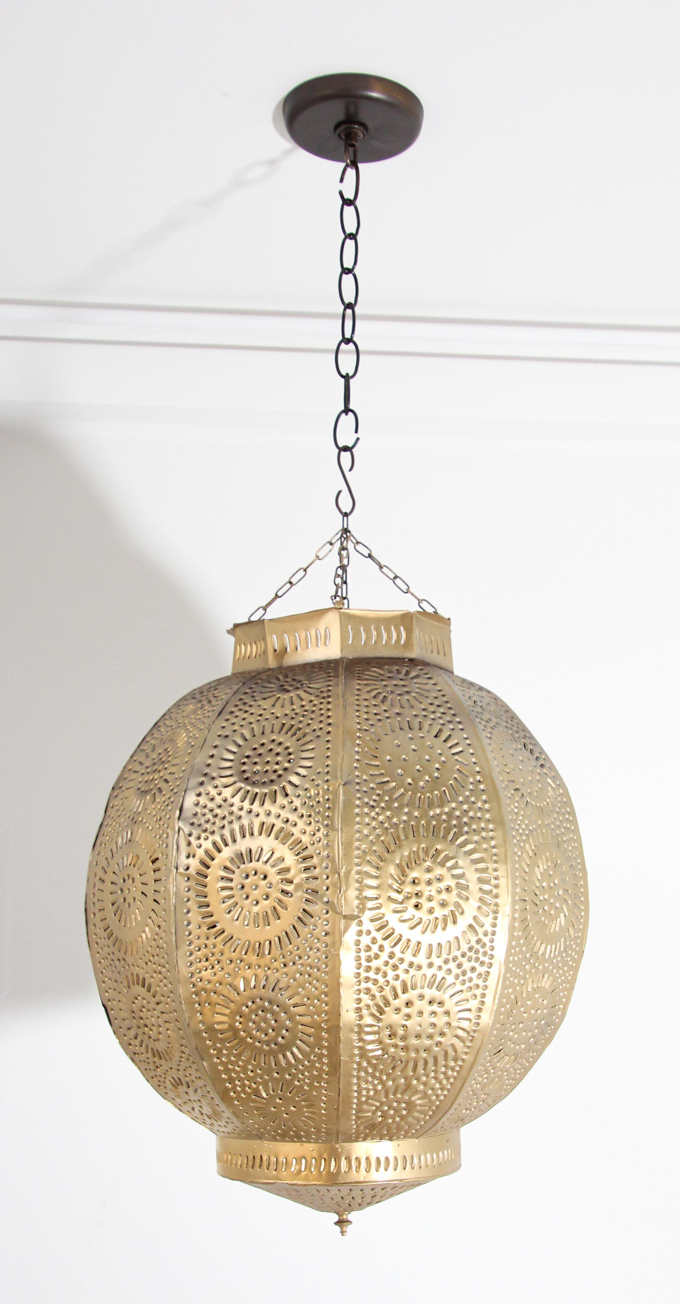 Gilt metal orb pendant handcrafted by skilled artisans in Morocco, North Africa.
Amazing metal Moroccan lantern hand-pierced with thousands of small holes to diffuse the light through.
Pomegranate shape adorned with Moorish design.
Handmade of light