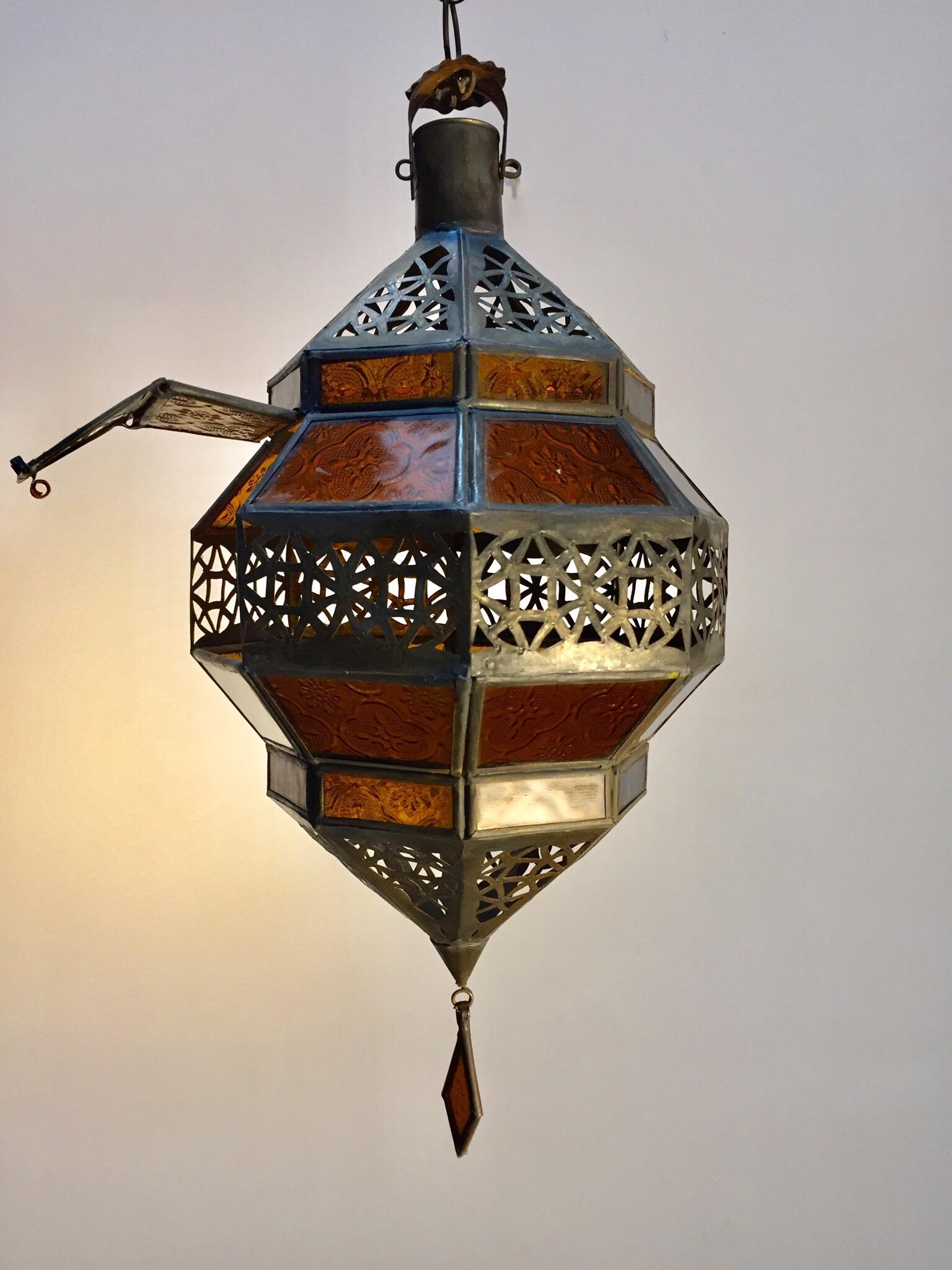 Moroccan metal and amber glass lantern in diamond shape.
Moroccan lantern in octagonal shape with rust color metal finish and amber glass.
The top and bottom hand-cut openwork metal with Moorish design.
This Moroccan lantern when lit will cast light