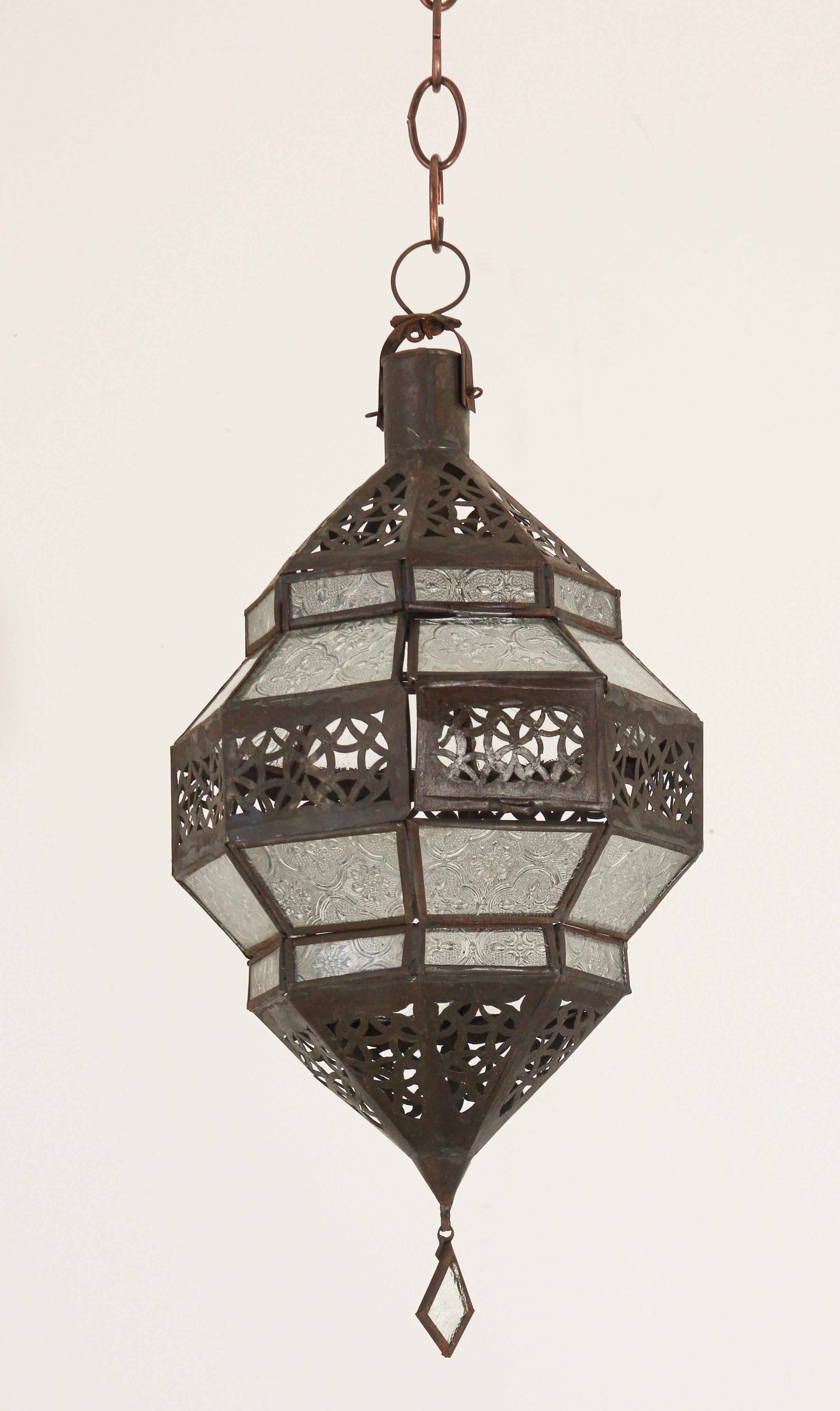 Moroccan metal and clear frosted glass lantern.
Moroccan lantern in octagonal shape with rust color metal finish and clear glass.
The top and bottom metal hand-cut in openwork Moorish design.
This Moroccan lantern when lit will cast light on the