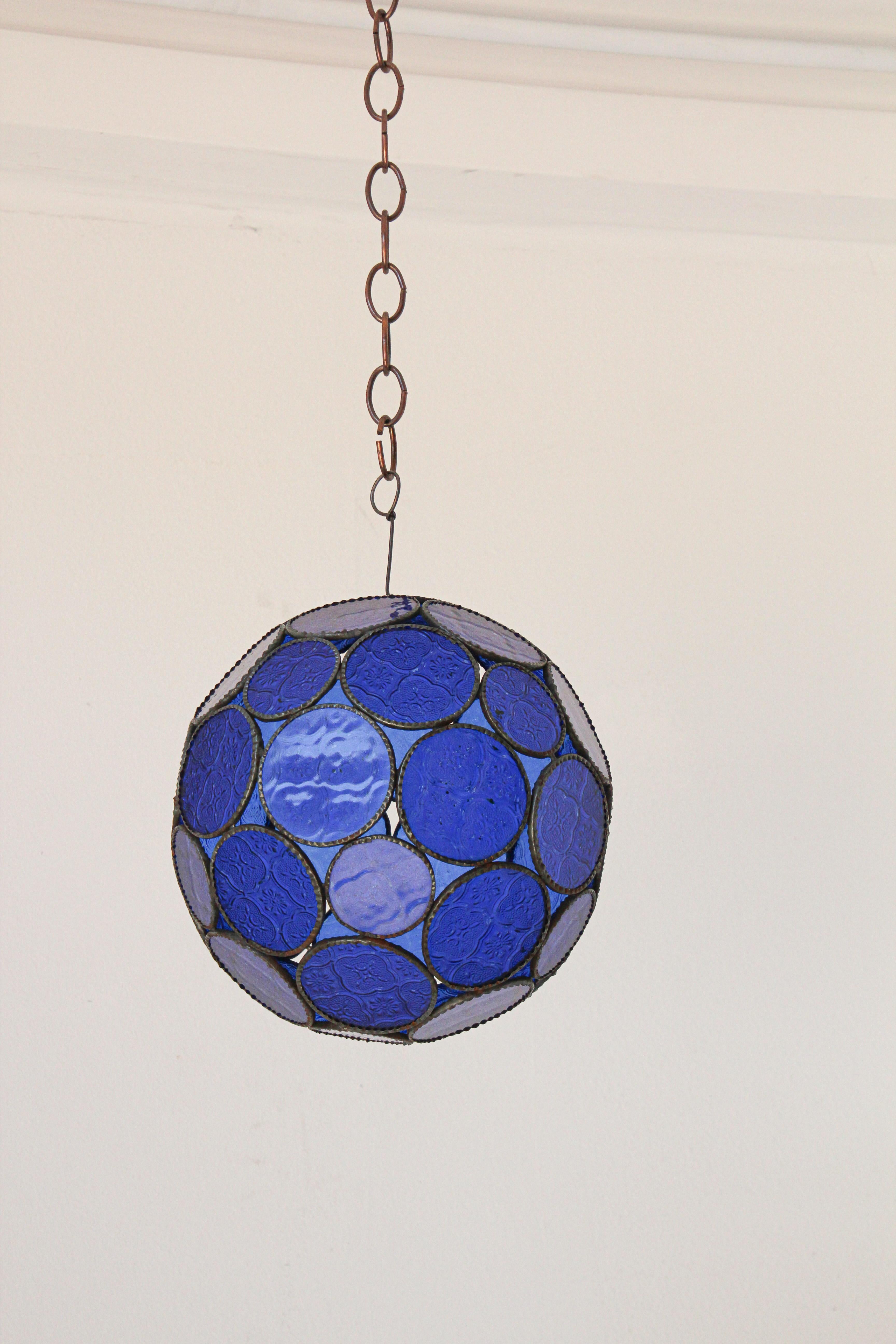 Handcrafted Moroccan cobalt blue glass lantern or Moorish pendant.
Cobalt blue molded glass color with Moorish design circles put together in an orb style lamp.
Handmade in Marrakech, metal rust color finish, colorful multifaceted orb glass