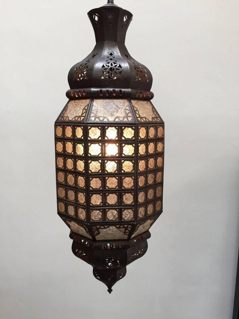 Moroccan Glass Lantern with Metal Filigree and Clear Glass.
Hand made using with small mosaic molded glass and cutout metal.
Create an exotic effect in your home or garden with magical old Moroccan lanterns created by craftsmen using tin and Moorish