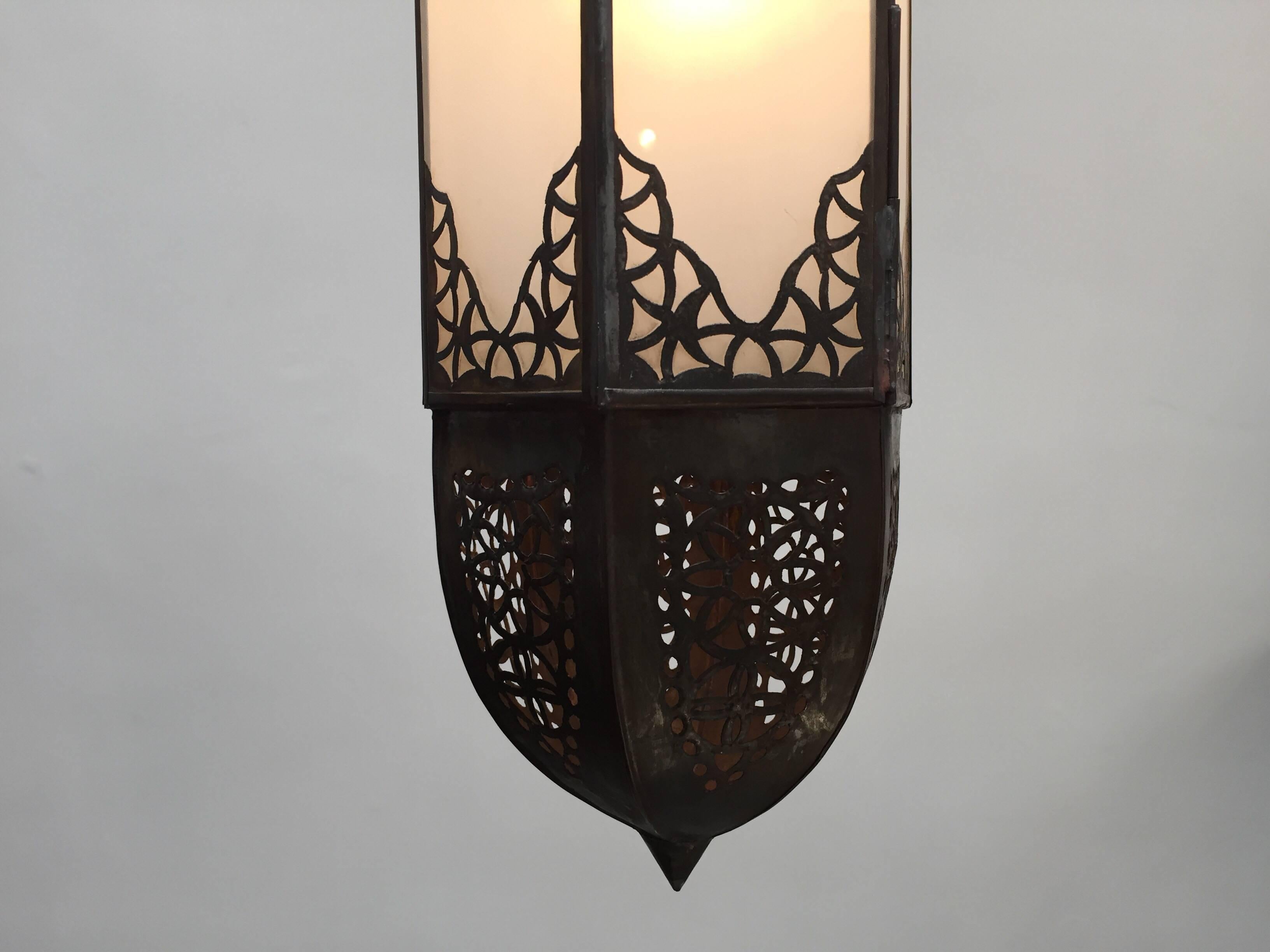 Handcrafted Moroccan Moorish metal and milky glass lantern, rewired ready to hang.
Elegant and stylish milky glass handcrafted Moroccan pendant light with intricate filigree work in the Moorish style.
Could be used as a wall sconces or hanging from