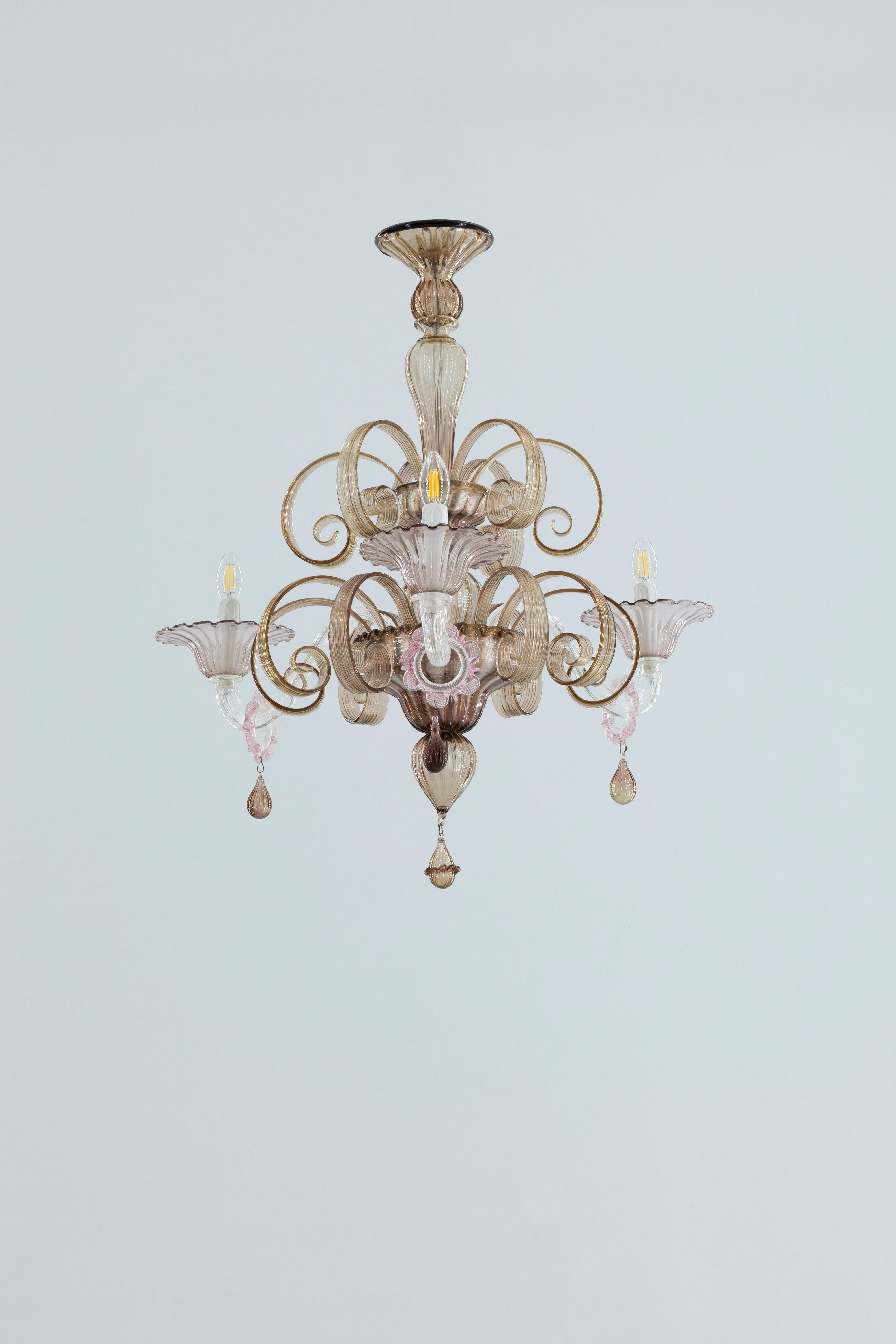 Fabrication artisanale  Lustre en verre de Murano, tourbillons d'ambre et détails rose tendre, 20e.

Élevez votre intérieur avec cet époustouflant lustre vintage en verre de Murano, véritable témoignage de l'art et du savoir-faire des verriers