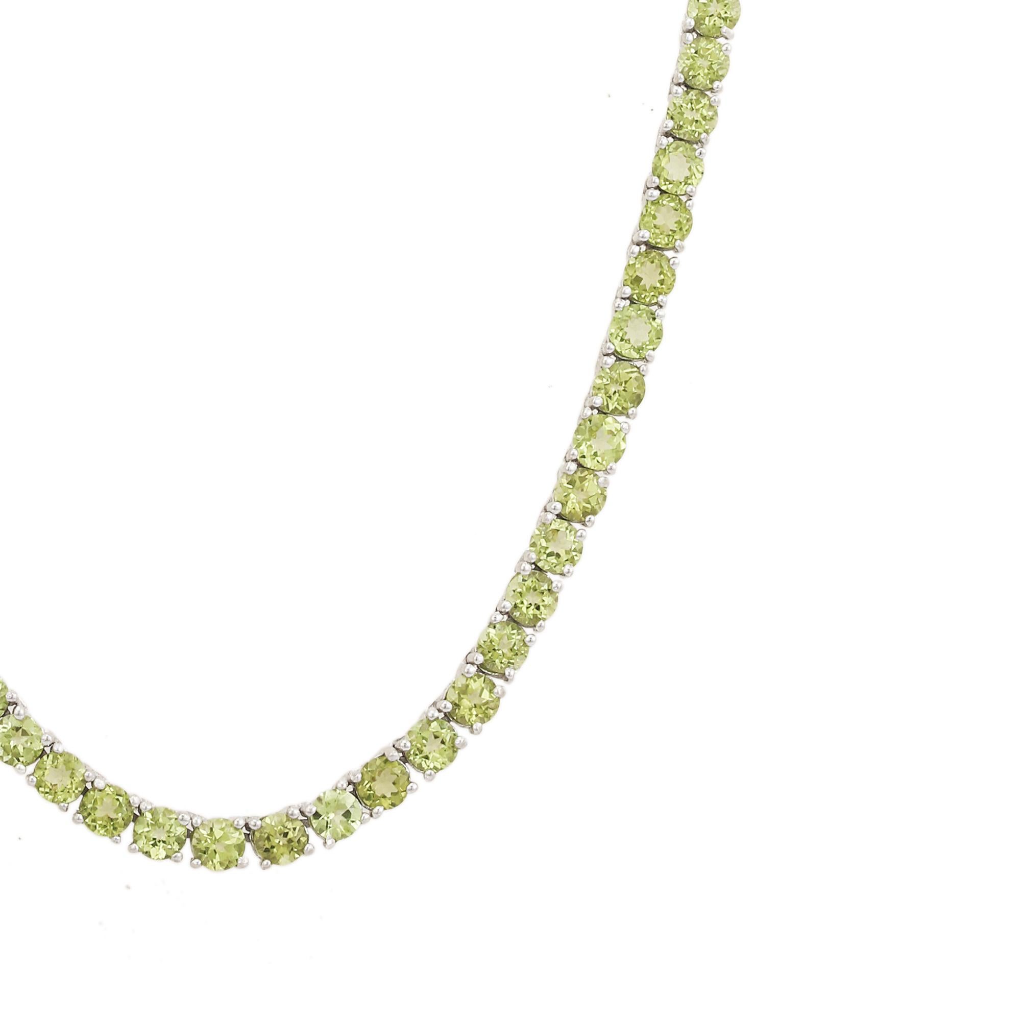 Este collar artesanal de tenis de peridoto verde natural es un exquisito collar de tenis de peridoto, hecho a mano en luminosa plata de ley 925. Con una línea continua de gemas redondas de Peridoto talla brillante en un elegante engaste de garras,