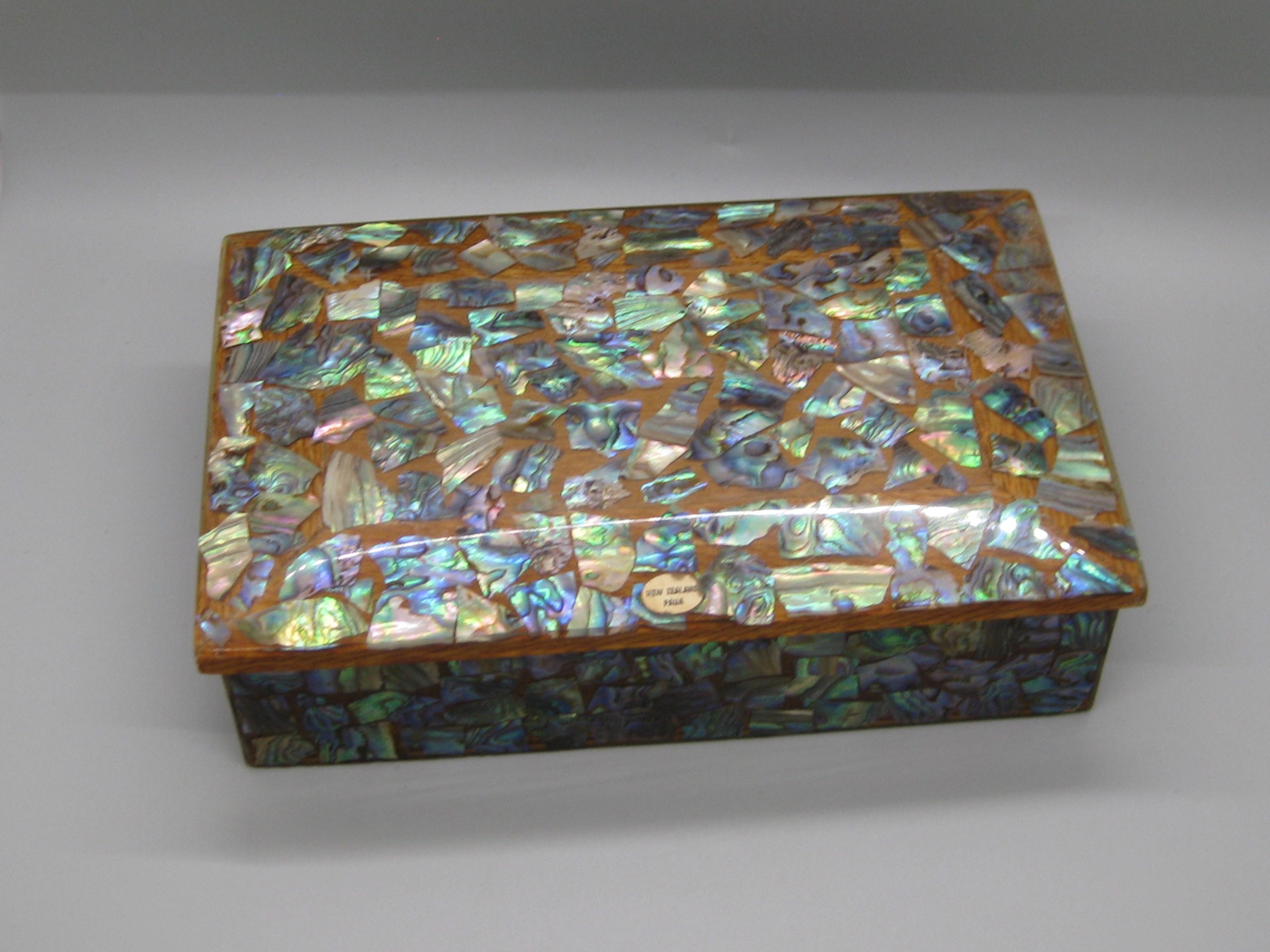 Preciosa tabaquera decorativa hecha a mano con madera de caoba e incrustaciones de concha de abulón natural (Paua). Fabricado en Nueva Zelanda y todavía tiene la etiqueta original en la parte superior. La caja tiene una forma y un diseño