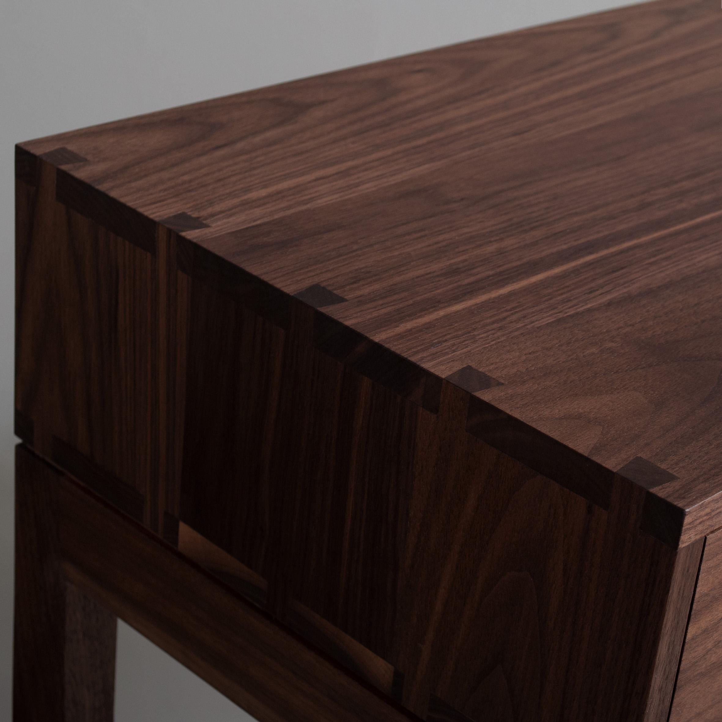 American black walnut hand-crafted nightstands or end tables in a midcentury modernist design. These are constructed from the finest American black walnut with the inner dovetailed traditionally jointed drawer carcass in prime English Oak. The main