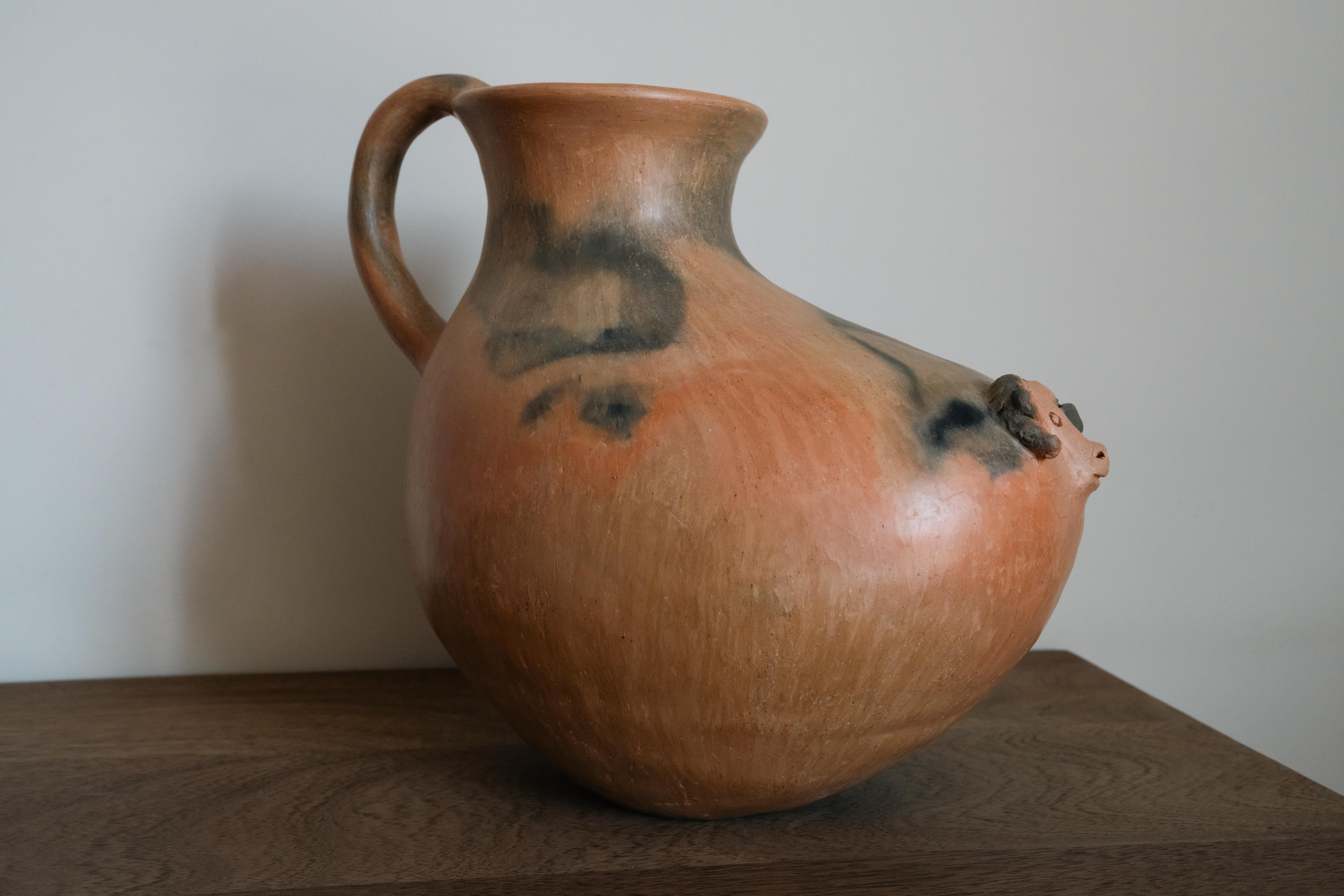 Una exquisita vasija de barro hecha a mano, una asombrosa fusión de tradición y diseño. Fabricada en las montañas del norte de Oaxaca, México, esta pieza única se moldea a mano y se cuece en un horno tradicional de madera, conservando técnicas