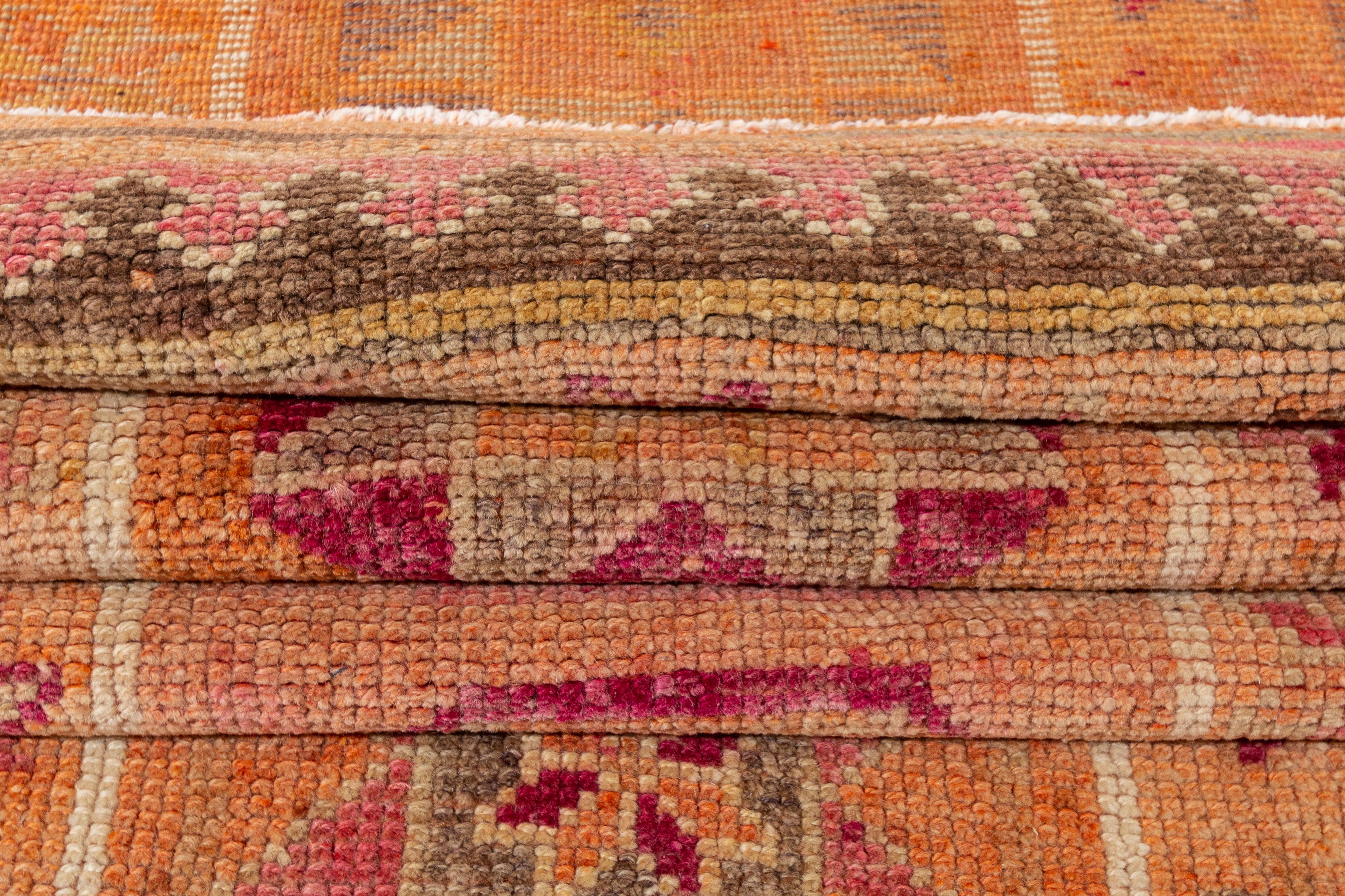 Alfombra de lana turca de Anatolia, anudada a mano, del siglo XX, con un campo naranja con detalles y motivos geométricos rosas.

Esta alfombra mide 3'2