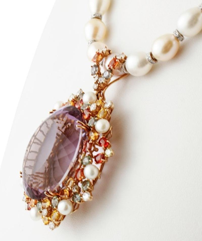 Vintage beaded necklace realized with baroque pearls set with a big pendant realized in 14k rose gold structure, mounted with a big faceted amethyst in the centre surrounded by decorations of diamonds, colored sapphires and little diamonds.
The