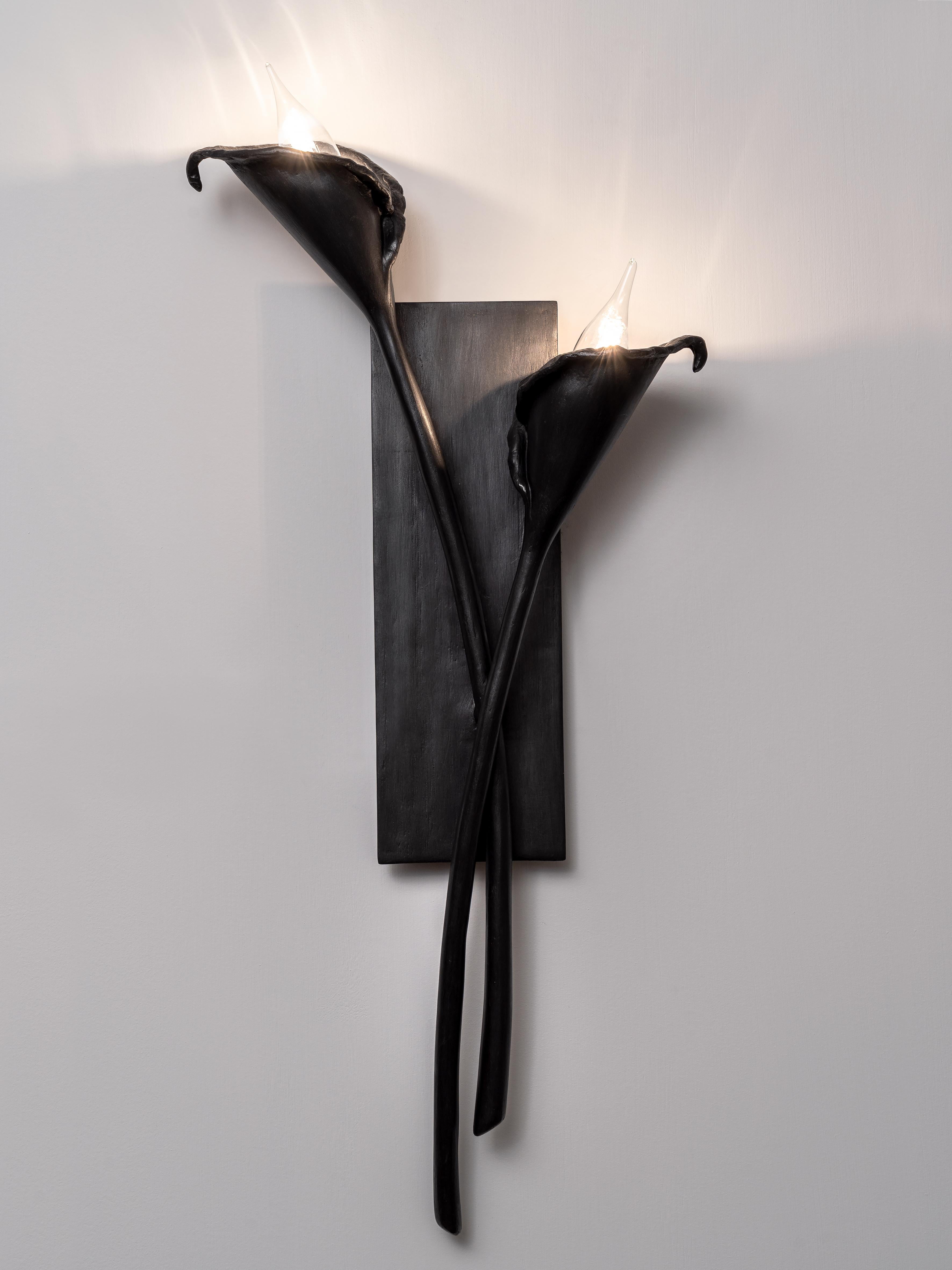 Hand-sculpted in plaster you can select from a single element or a pair of Calla Lily Wall Light. Available in white and black plaster finish. 
Each piece is hand of a cut, individually hammered, hand formed, then meticulously sculpt and sand it