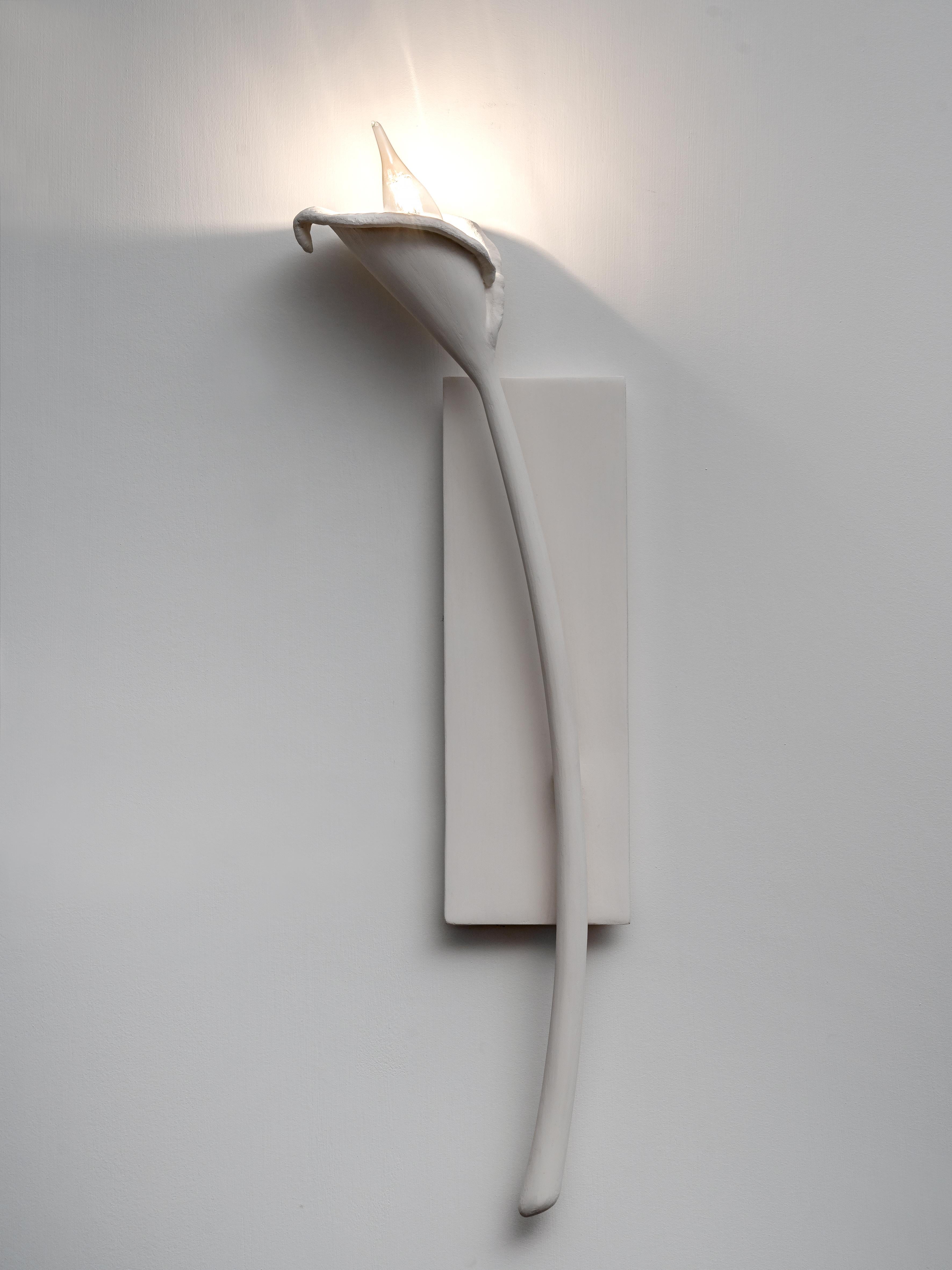 Hand-sculpted in plaster you can select from a single element or a pair of Calla Lily Wall Light. Available in white and black plaster finish, in left and right version.  
Each piece is hand of a cut, individually hammered, hand formed, then