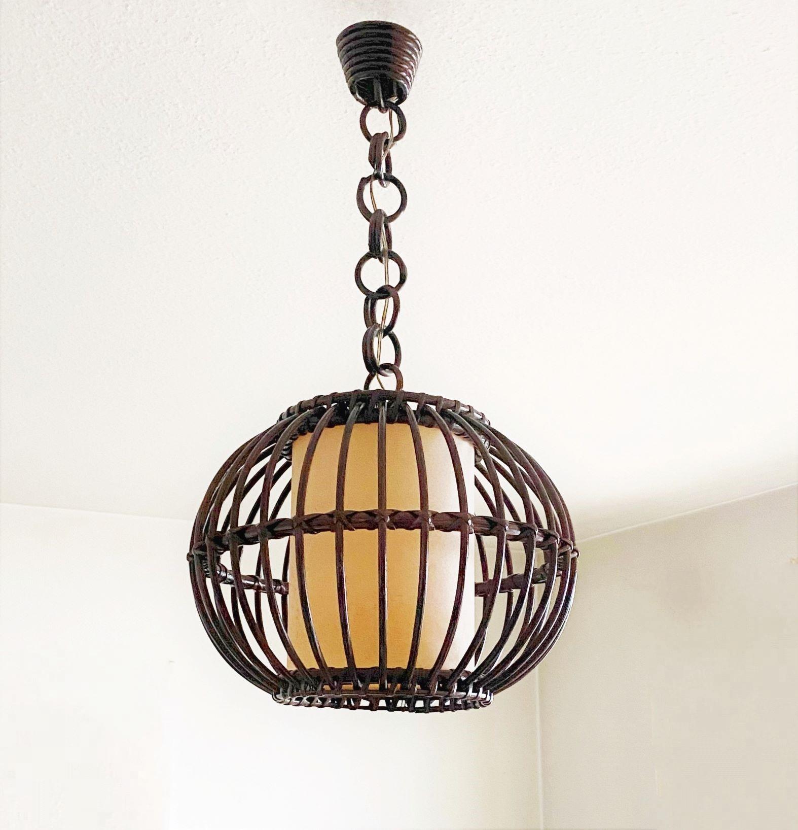 Mid-Century rattan and wicker globe pendant, Spain, 1950s. This beautiful suspension lamp is entirely handcrafted in rattan and wicker, with a central cylinder parchment lamp shade provinding a warm and pleasant light. The chain is composed of