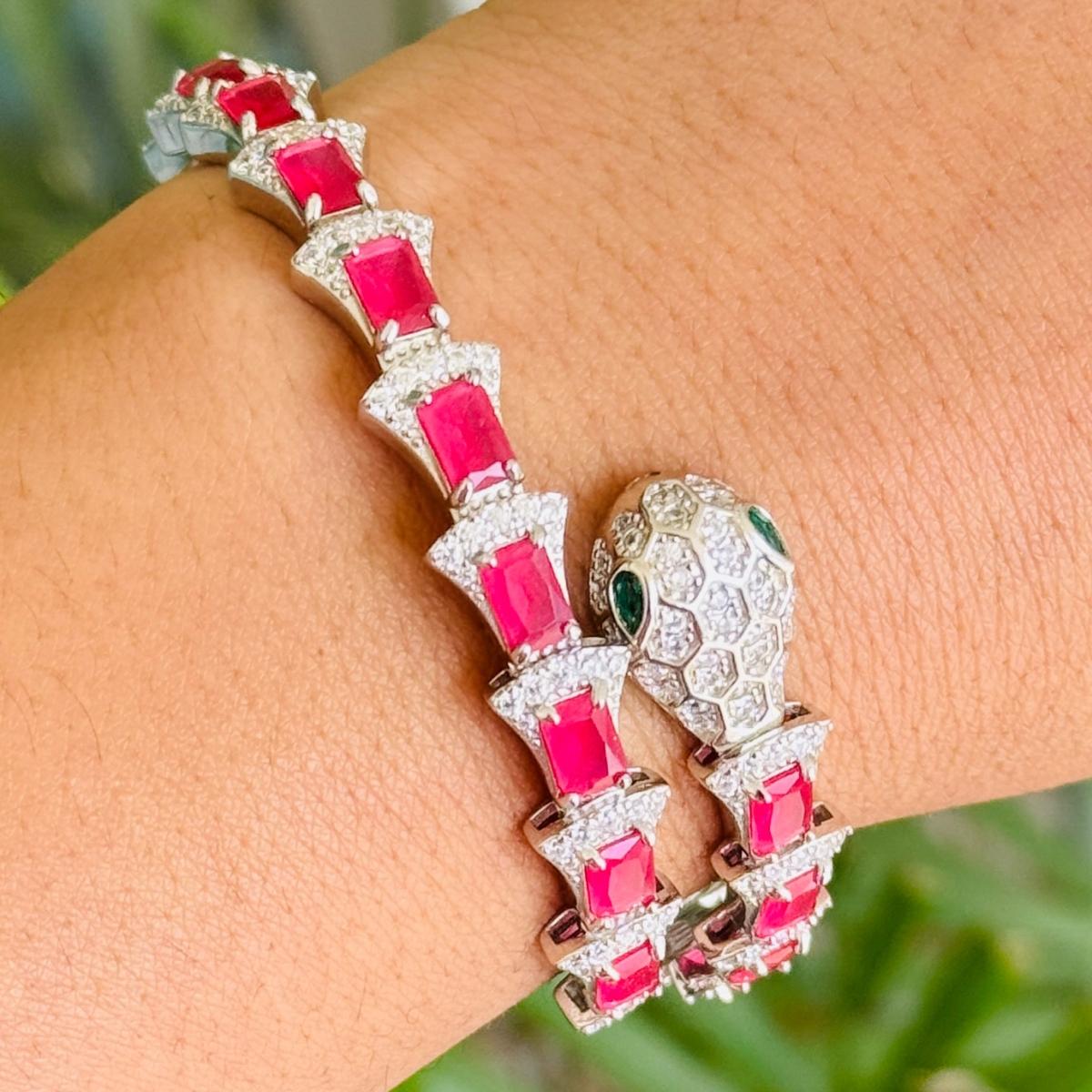Questo bracciale artigianale con zirconi rossi e diamanti a forma di serpente in argento sterling 925, splendidamente disegnato in stile serpentina, presenta un'impressionante disposizione di pietre di zirconia cubica color rubino intenso,