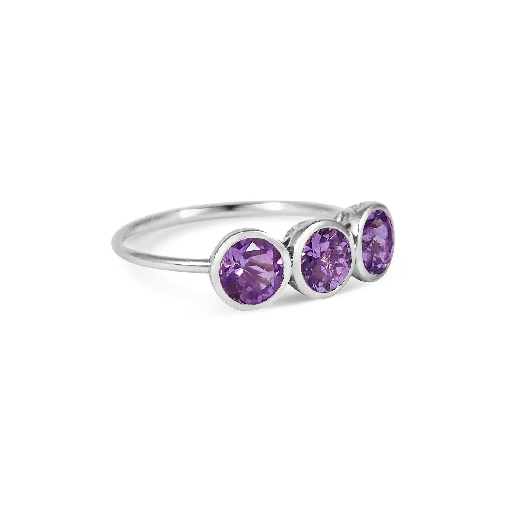 Handcrafted Round Cut 1.50 Carats Amethysts 18 Karat White Gold Three-Stone Ring. This classic three-stone or trilogy ring features round brilliant cut stones set in a rub over setting on a simple band. The 6mm natural Amethyst stones are set in